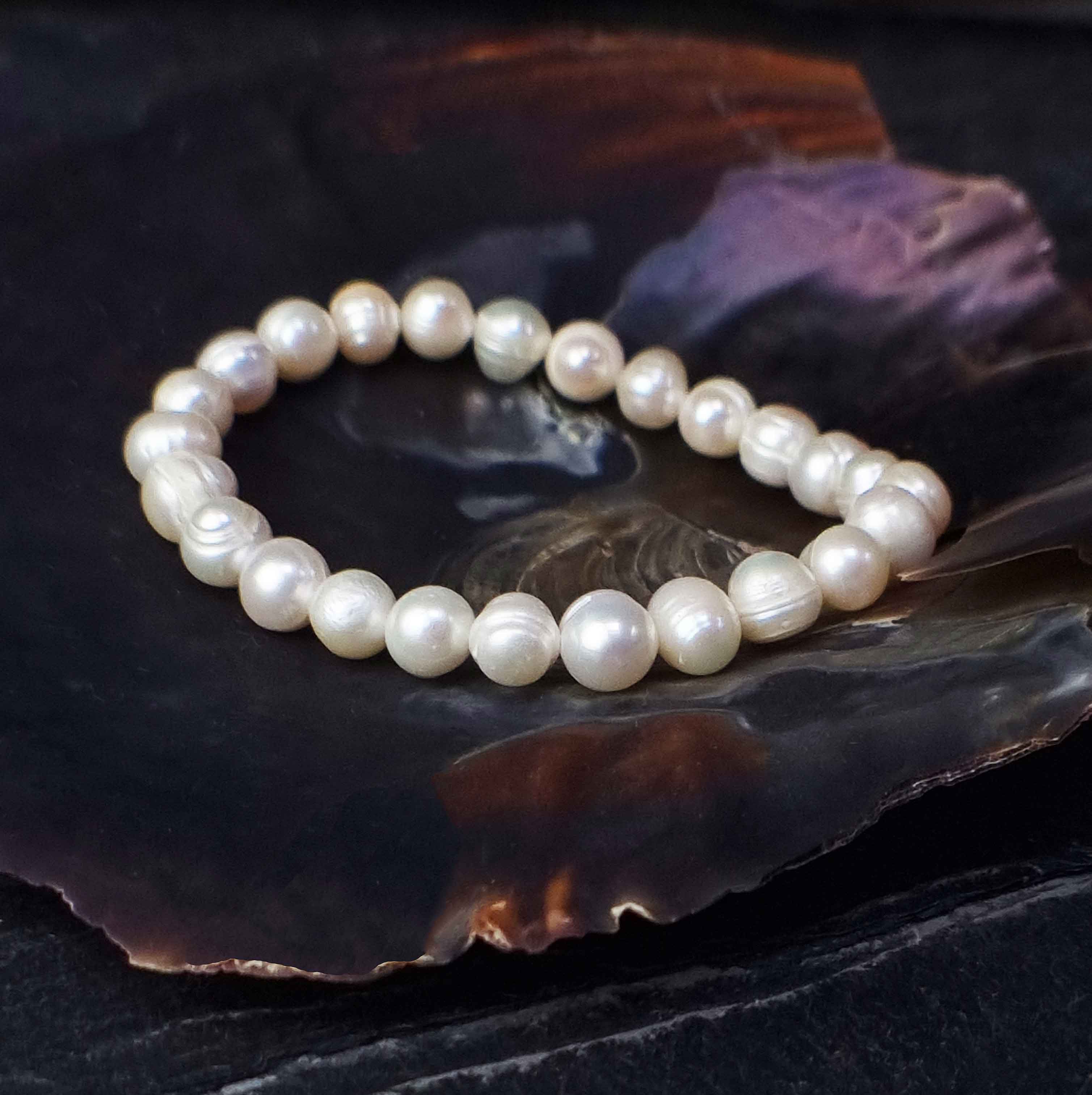 Wit elastisch zoetwater parel armband liggend in schelp | Round White