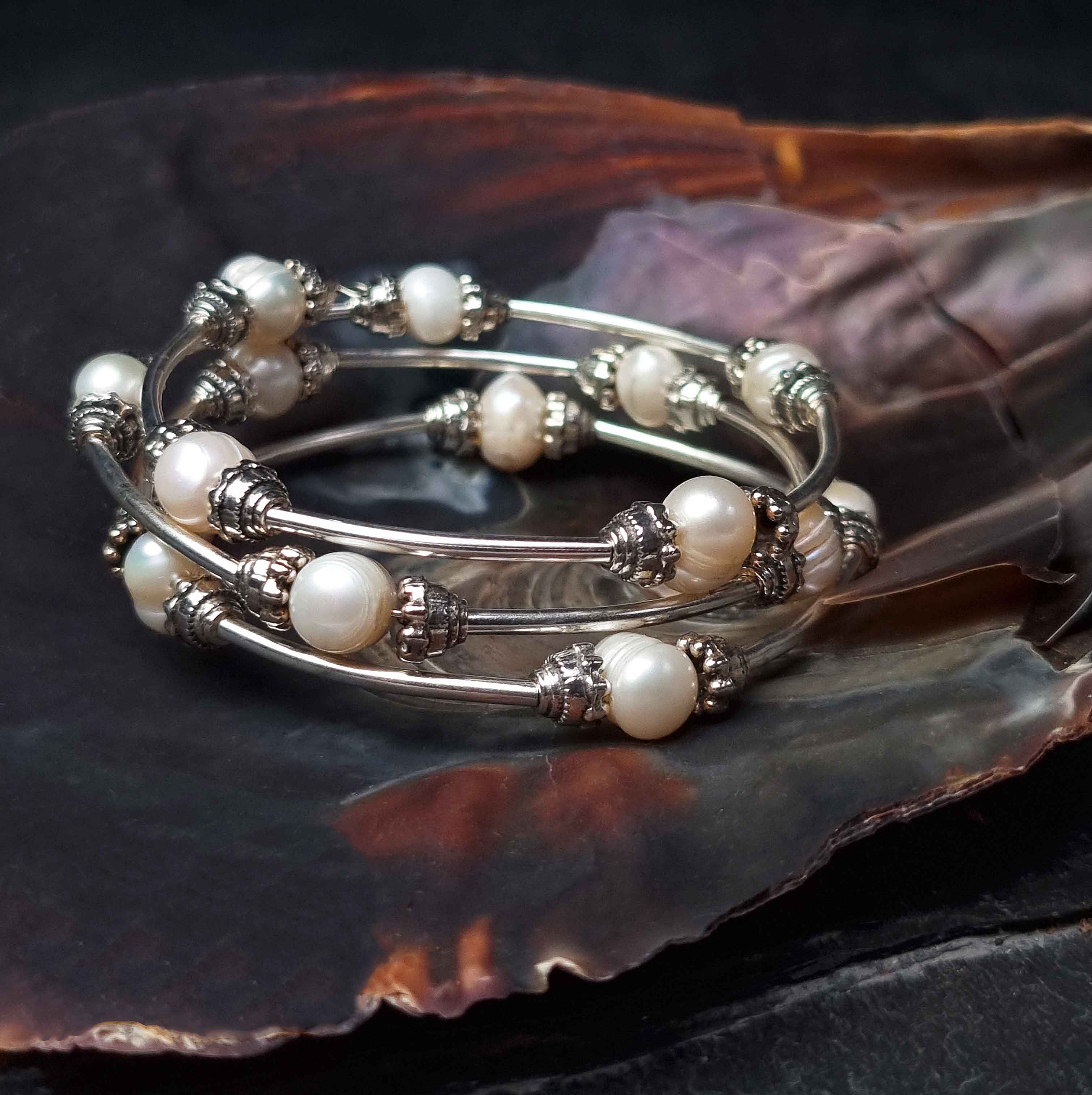 Wit zoetwater parel wikkelarmband liggend in schelp| Three Loops White Pearlarmband