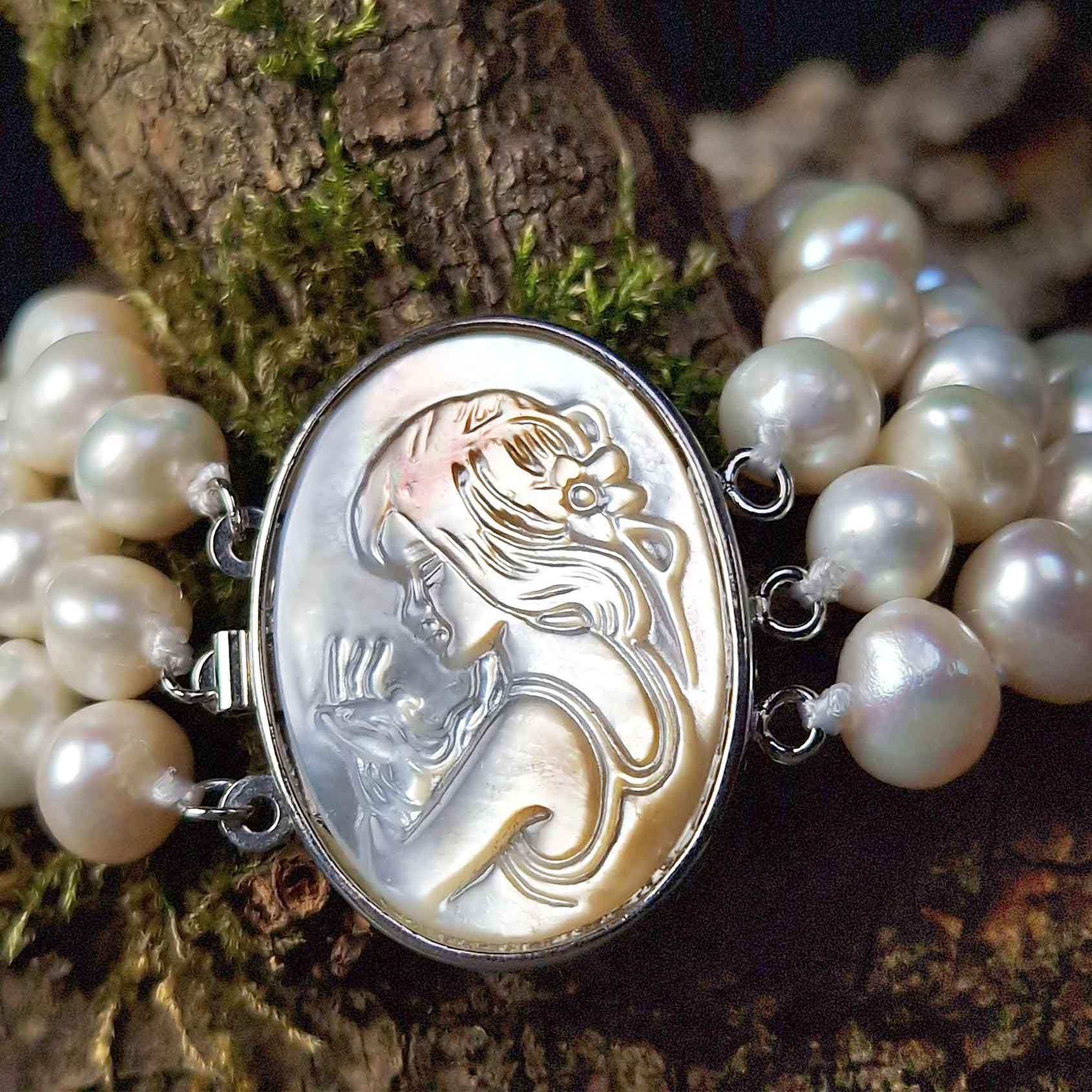 Wit handgeknoopt zoetwater parel armband in 3 rijen met parelmoer liggend op hout | Victoria