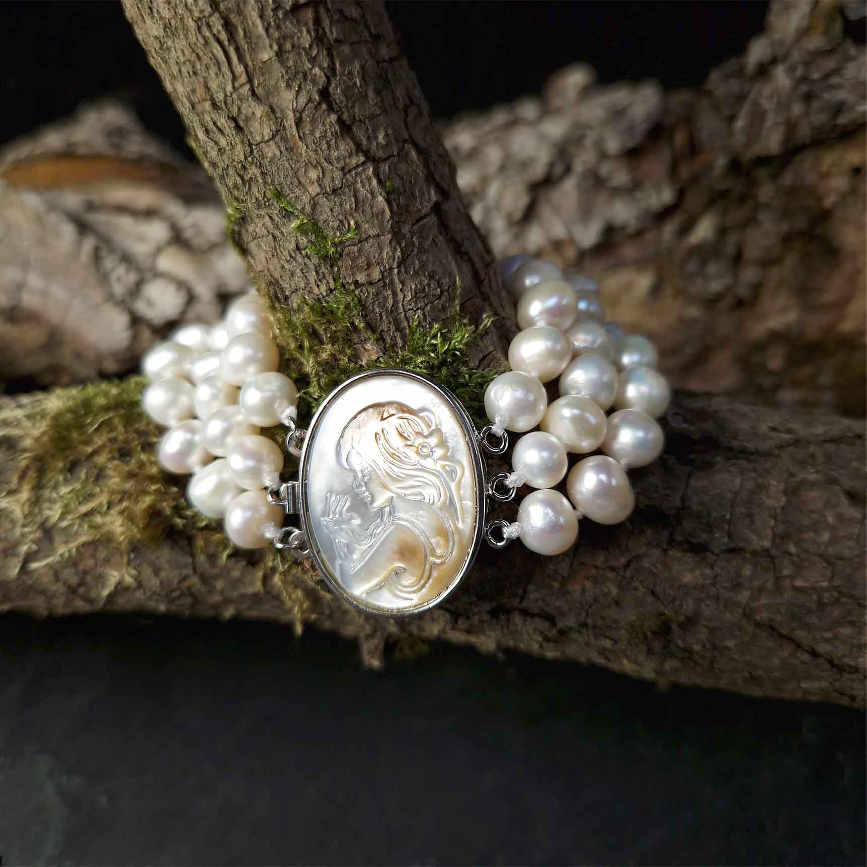 Wit handgeknoopt zoetwater parel armband in 3 rijen met parelmoer liggend om tak| Victoria