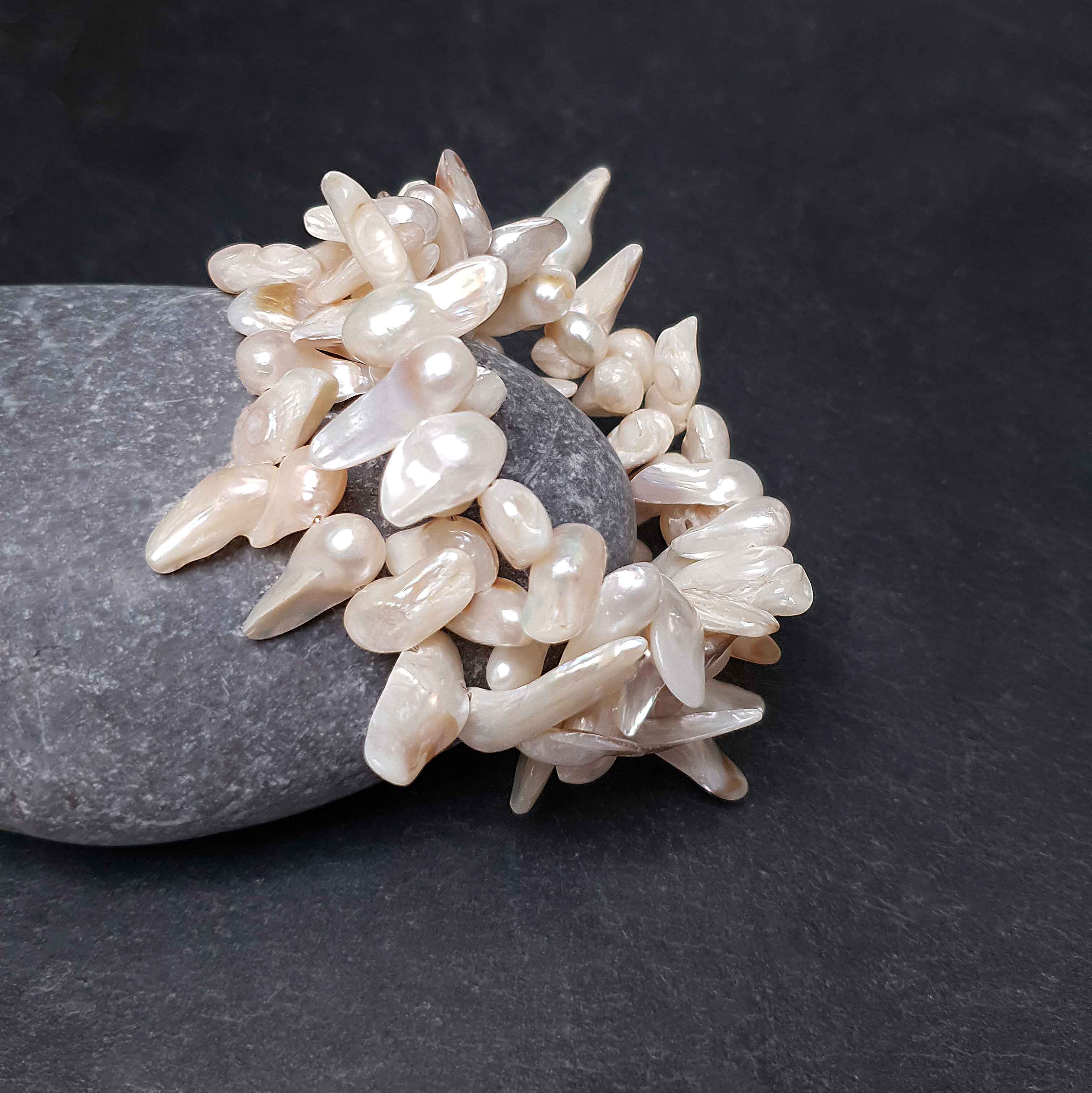 Wit zoetwater parel wikkel armband, zijaanzicht tegen kei | Winky