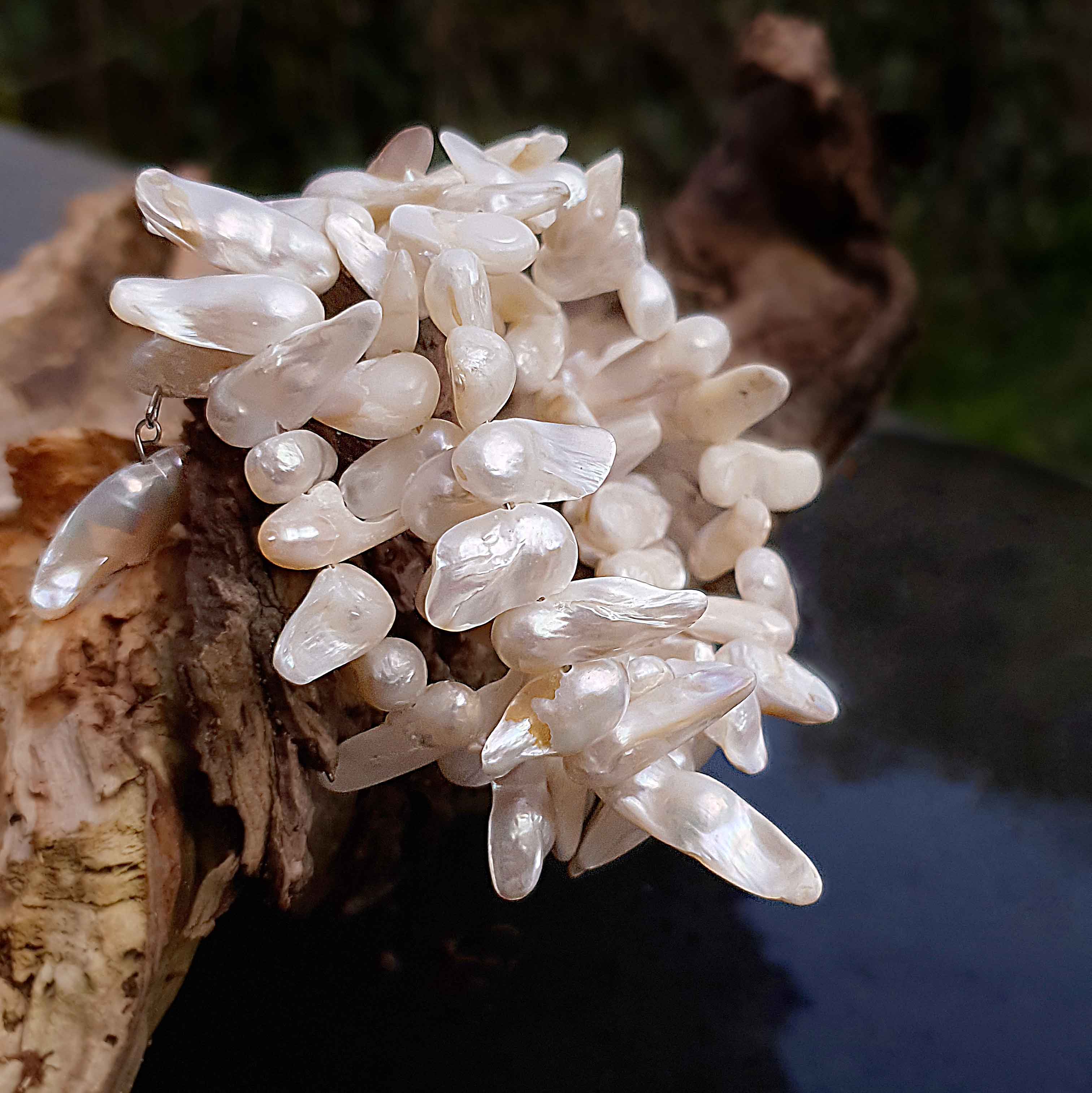 Wit zoetwater parel wikkel armband, zijaanzicht met achtergrond stronk | Winky