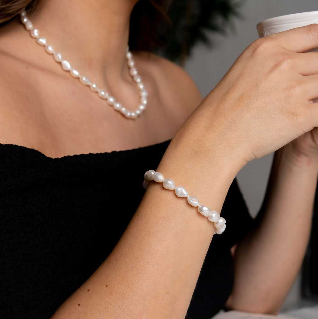 Wit zoetwater parel armband, handgeknoopt op model en drinkt thee | Wola