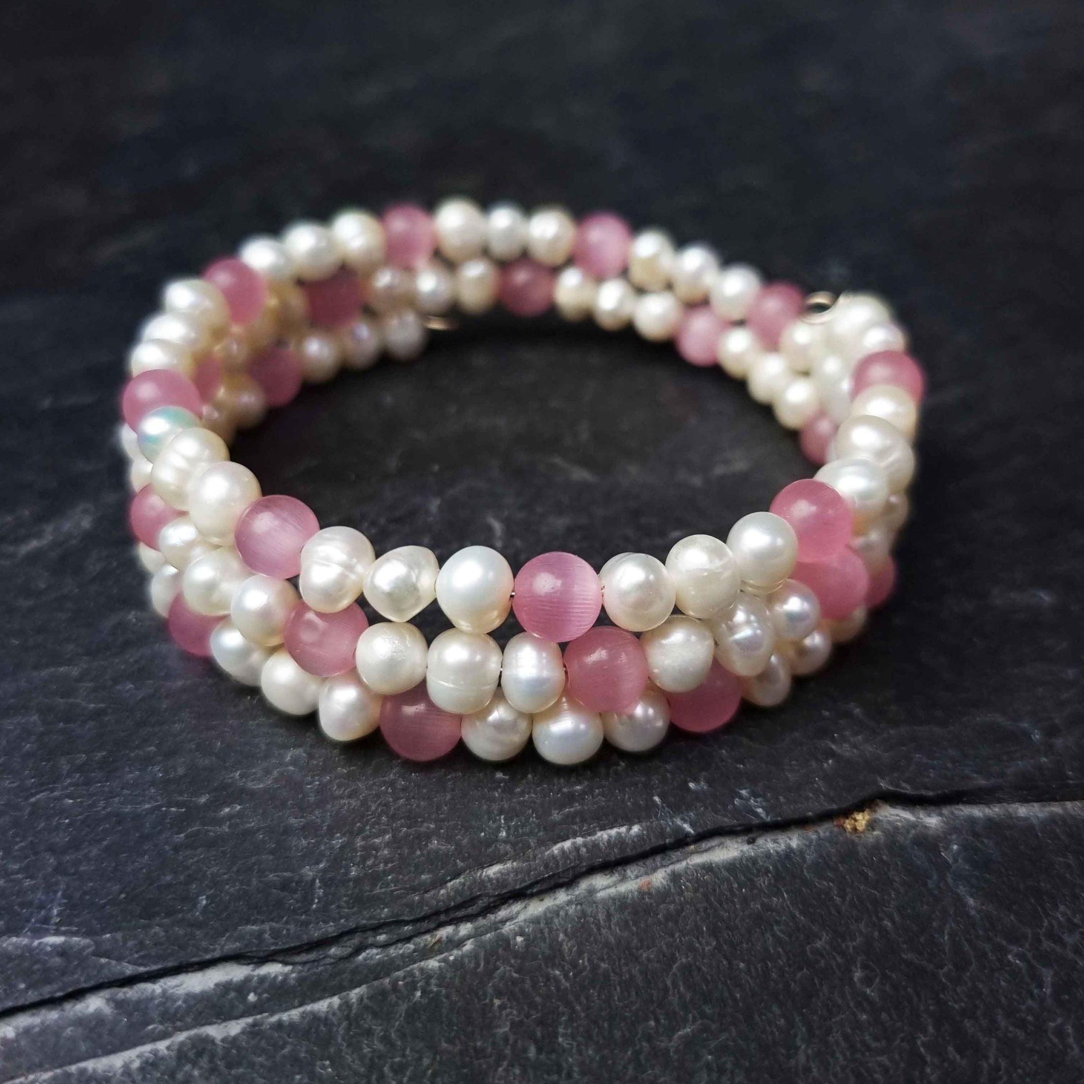 Wit zoetwater parel wikkelarmband met roze edelsteen kattenoog liggend op leisteen | Pearl Pink Cat&