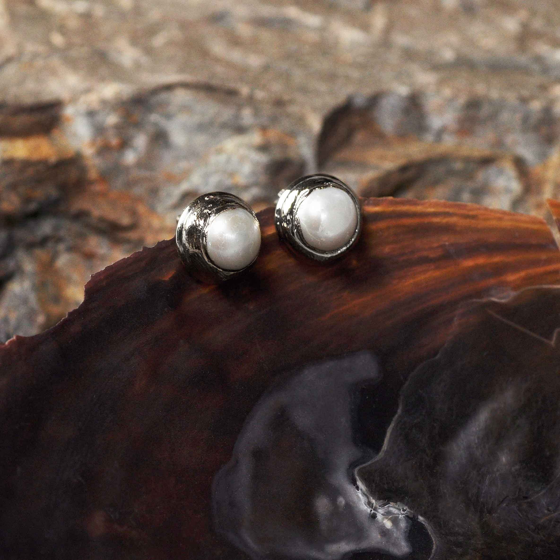 Witte zoetwater parel clips oorbellen met zilveren rand hangend aan schelp zijaanzicht | One Silver Clip Pearl