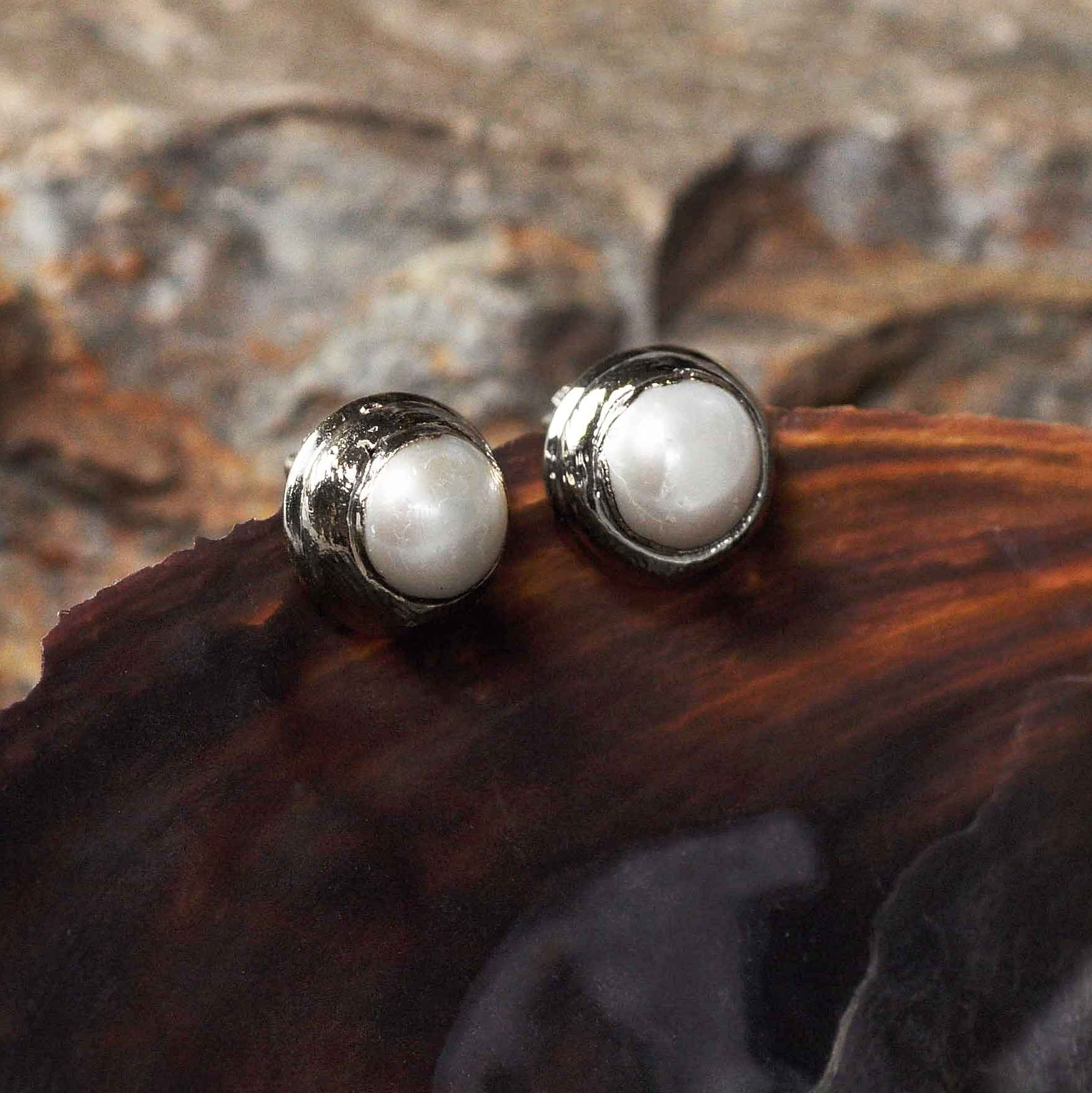 Witte zoetwater parel clips oorbellen met zilveren rand hangend aan schelp zijaanzicht | One Silver Clip Pearl