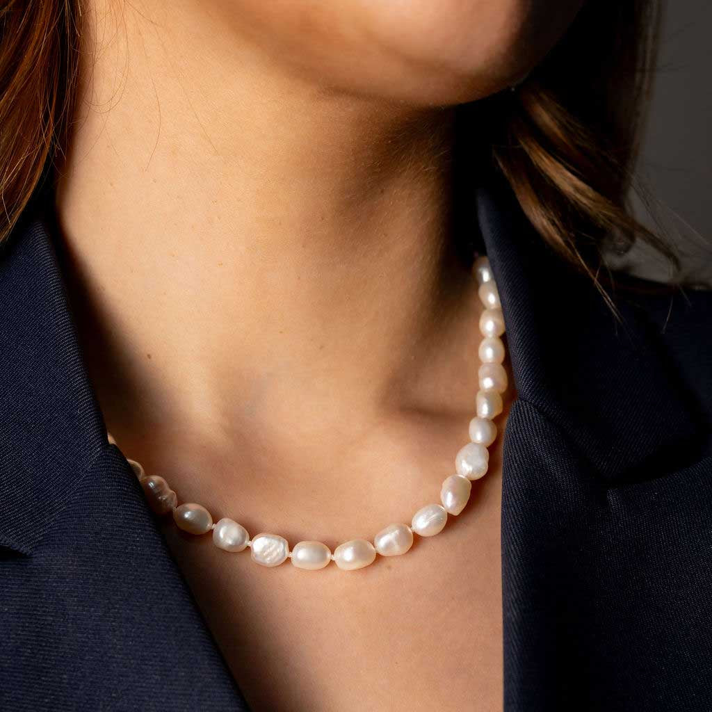 Handgeknoopte zoetwater parelketting met witte parels op model met blauw jasje | Wola