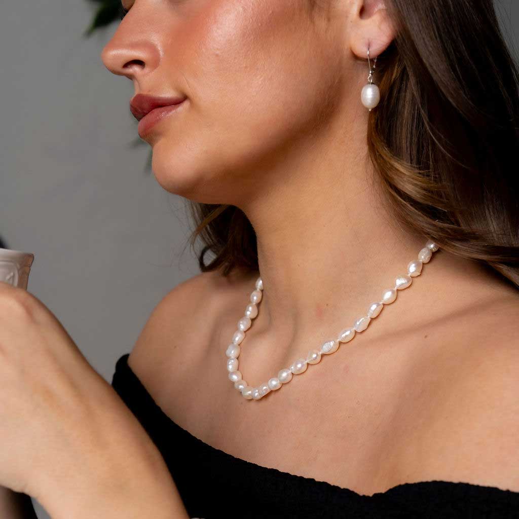 Handgeknoopte zoetwater parelketting met witte parels op model met zwarte jurk | Wola