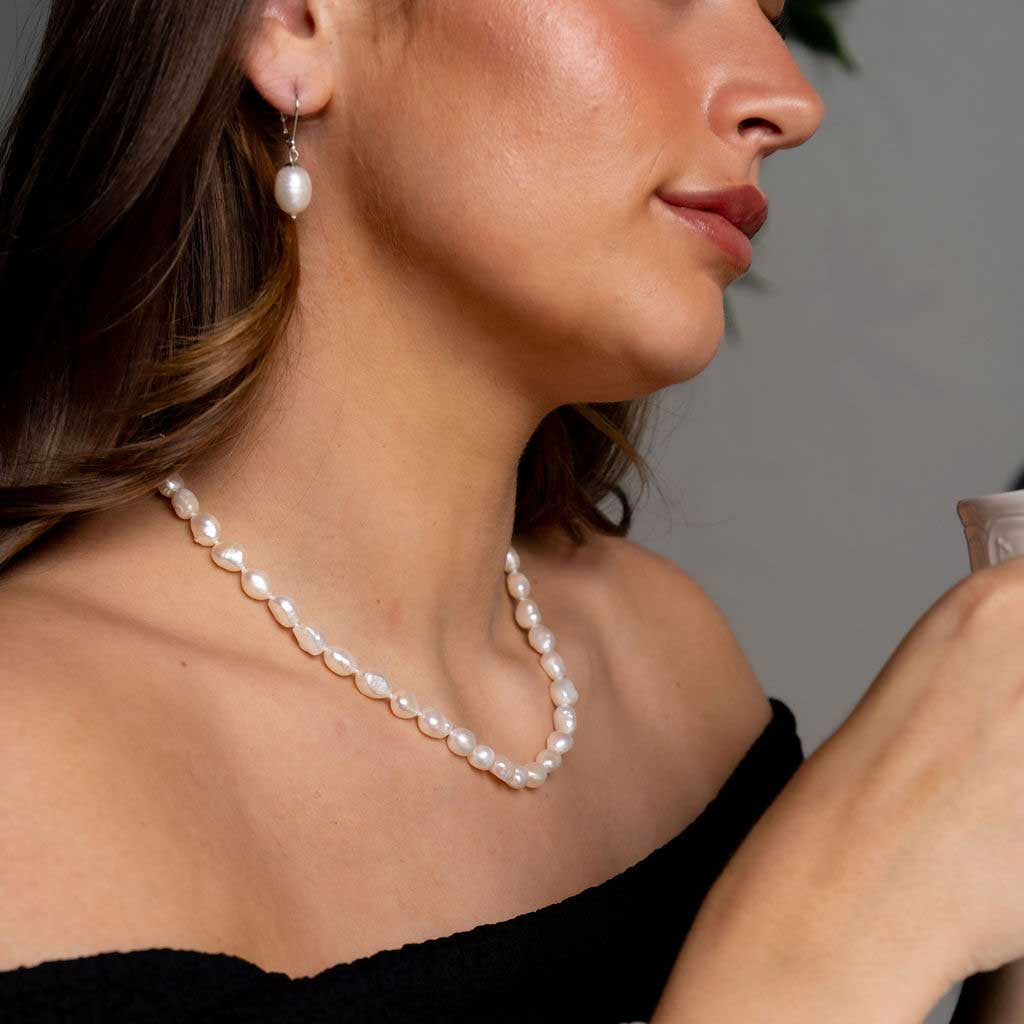 Handgeknoopte zoetwater parelketting met witte parels op model met zwarte jurk | Wola