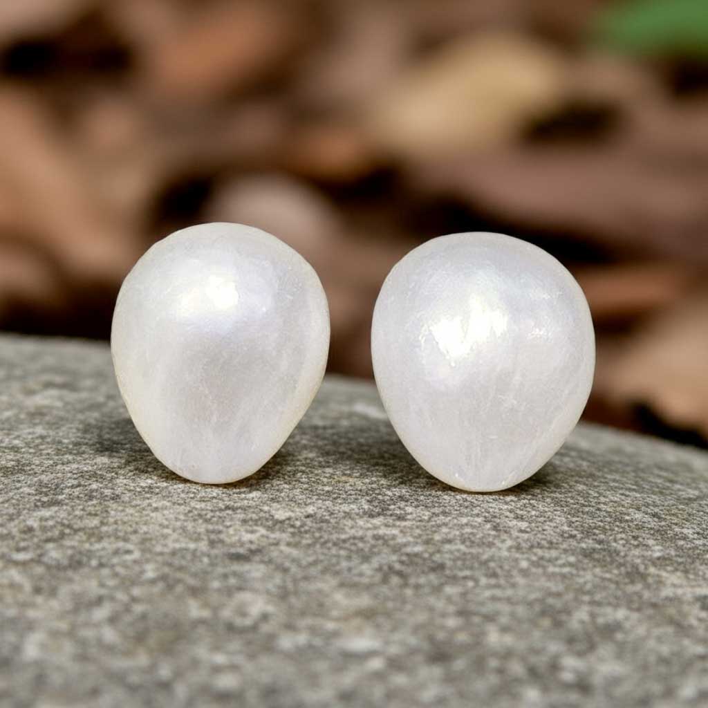 Witte barok parel oorbellen met sterling zilveren oorstekers, grote witte zoetwater parel oorknoppen met sterling zilver (925) liggend op grijze steen | Small White Baroque Pearl