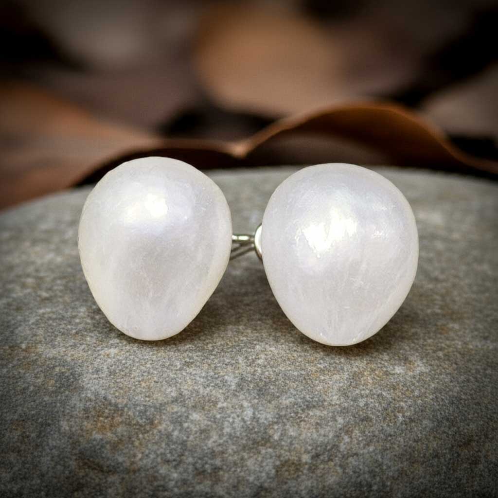 Witte barok parel oorbellen met sterling zilveren oorstekers, grote witte zoetwater parel oorknoppen met sterling zilver (925) liggend op steen | Small White Baroque Pearl