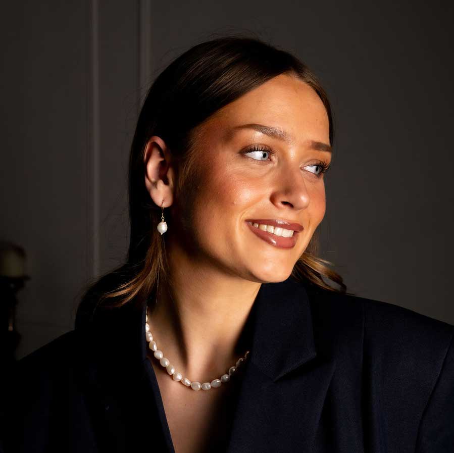 Witte zoetwater parel oorbellen met goud edelstaal op model | Abby