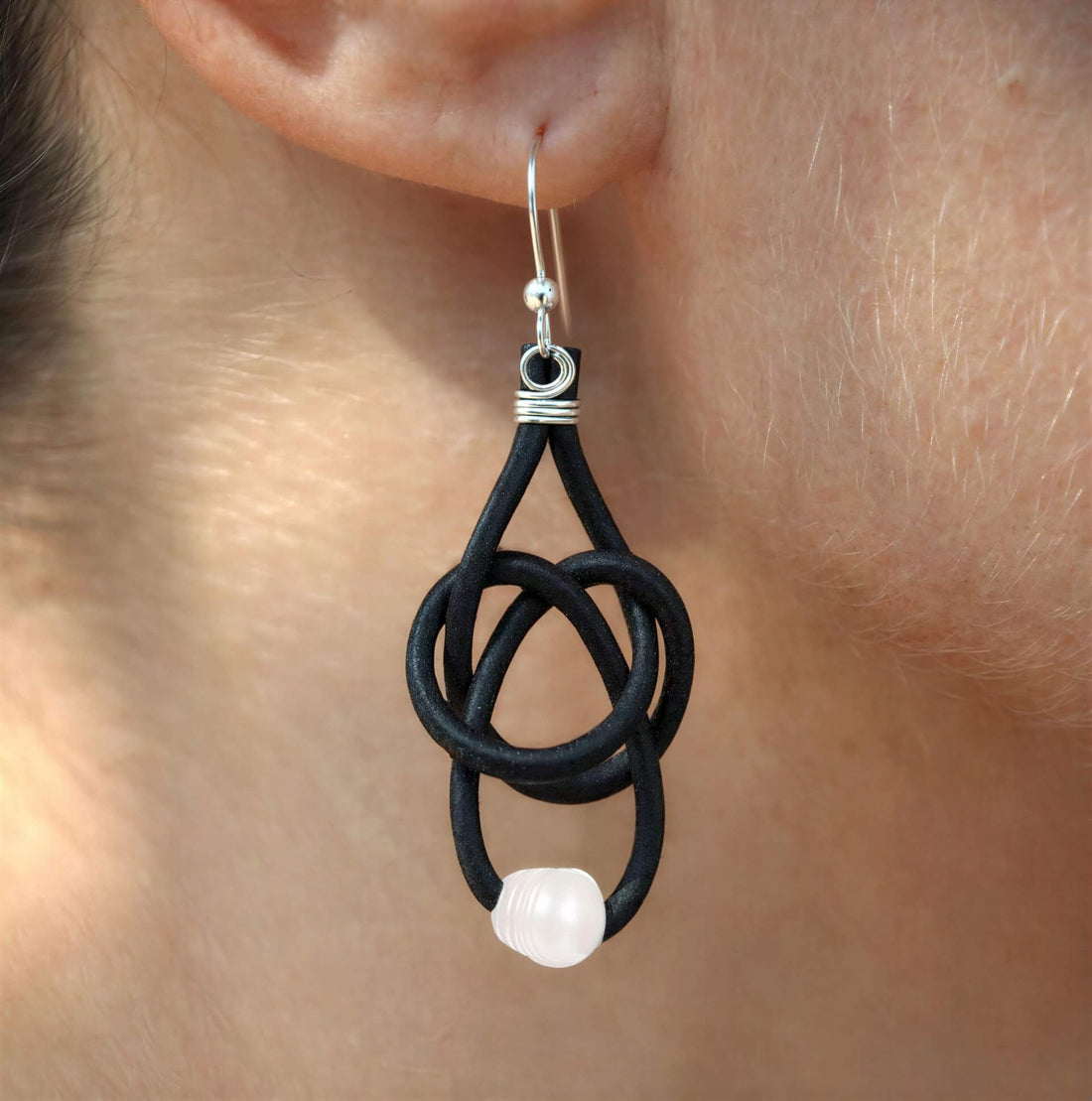 Witte zoetwater parel oorbellen met zwart leer en sterling zilver (925) hangend in oor | Black Leather Pearl White