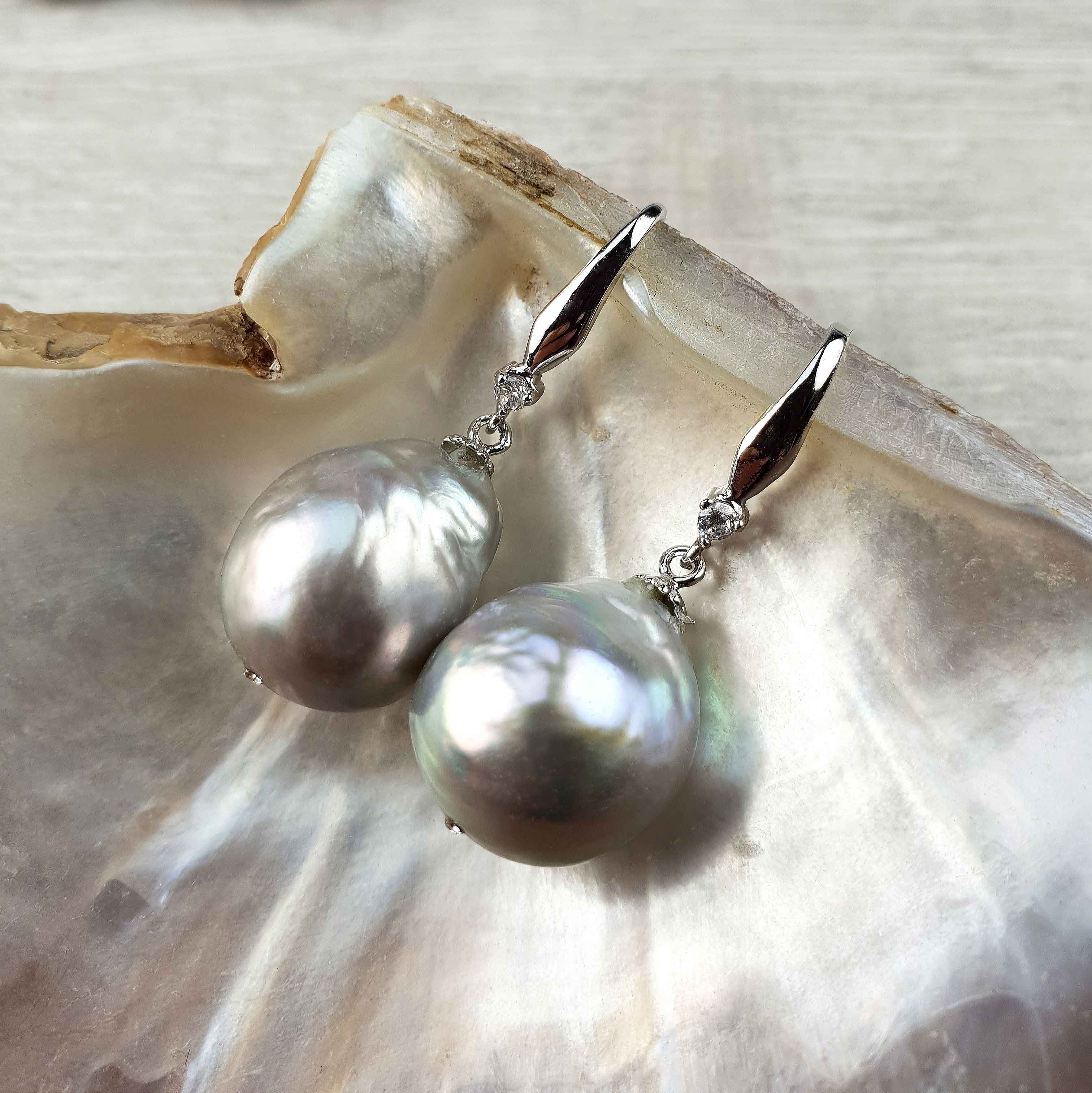 Grijze zoetwater parel oorbellen met sterling zilveren oorbelhaakjes en stras steentje liggend in schelp | Bling Kasumi Grey Pearl