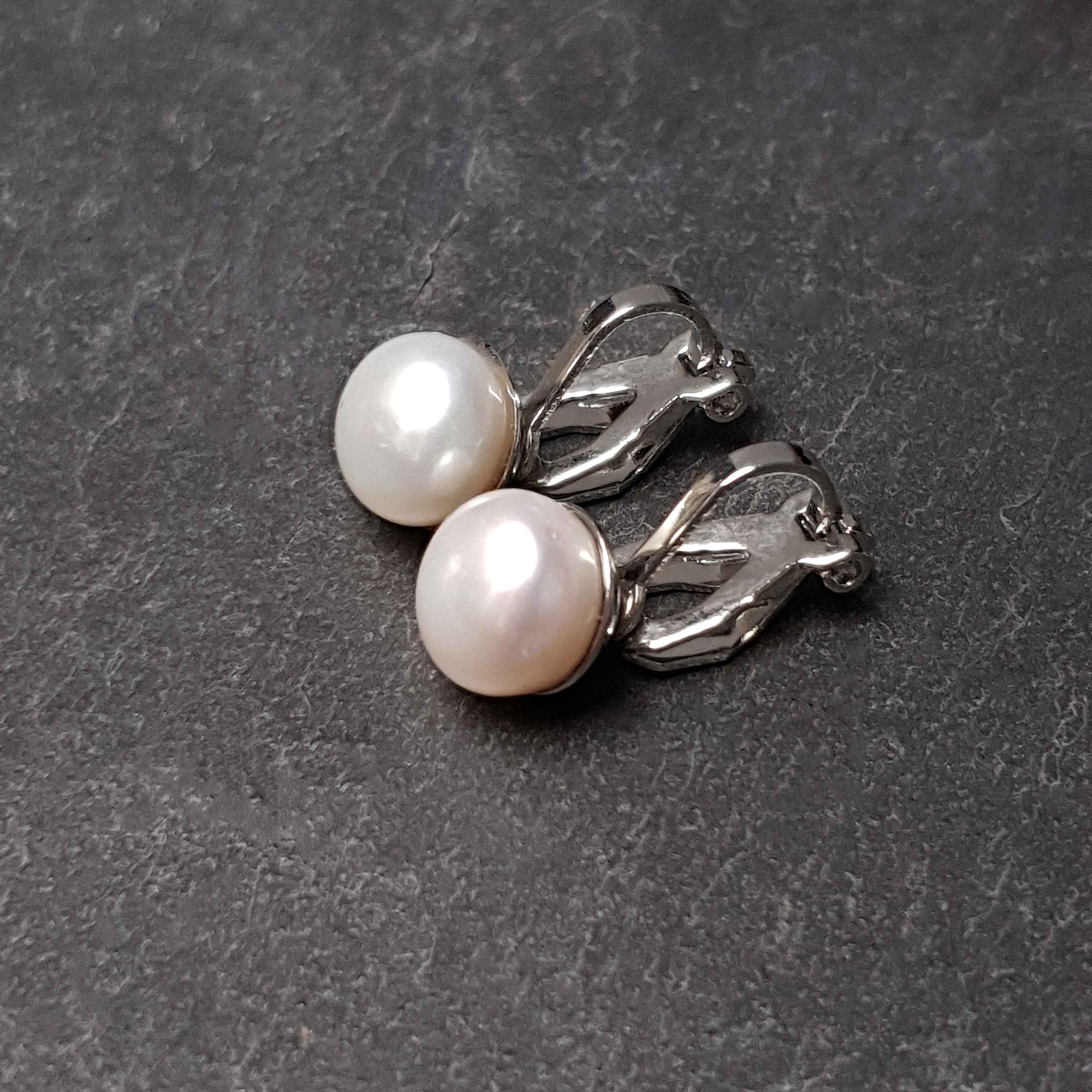 Witte zoetwater parel oorbellen met clip, clip oorbellen met parel liggend op leisteen, zijaanzicht | Clip Pearl