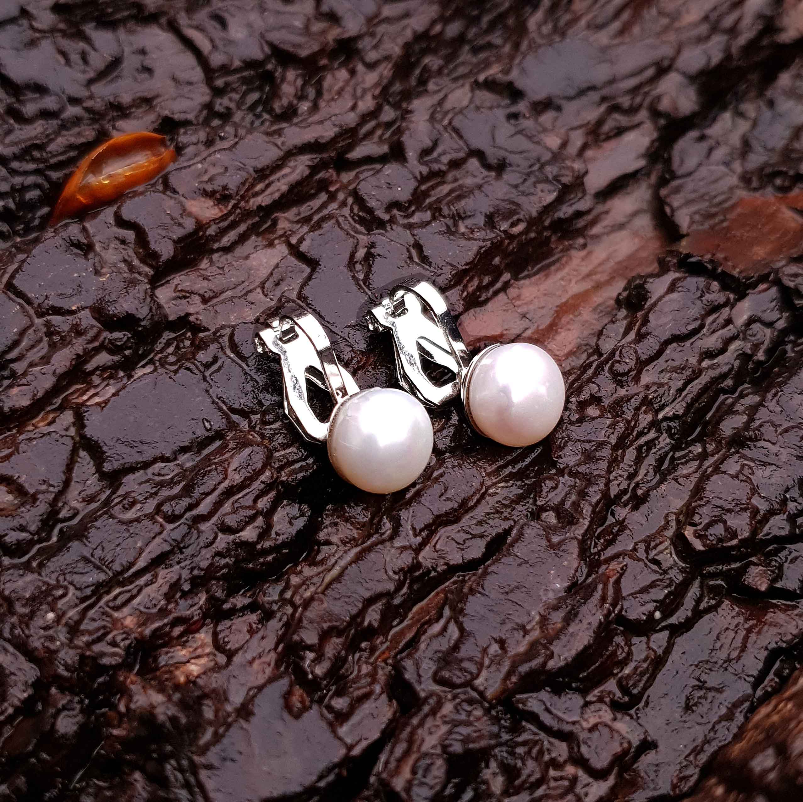 Witte zoetwater parel oorbellen met clip, clip oorbellen met parel liggend op schors | Clip Pearl