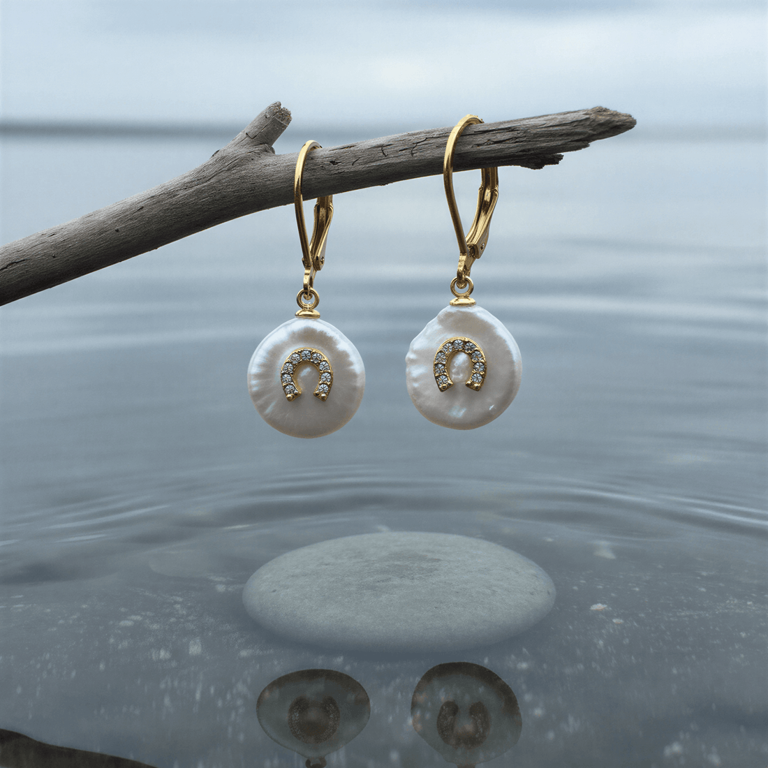 Witte zoetwater parel oorbellen met goud edelstaal en parel hanger is voorzien van stras steentjes in een hoefijzer hangend aan takje | Coin Pearl Good Luck