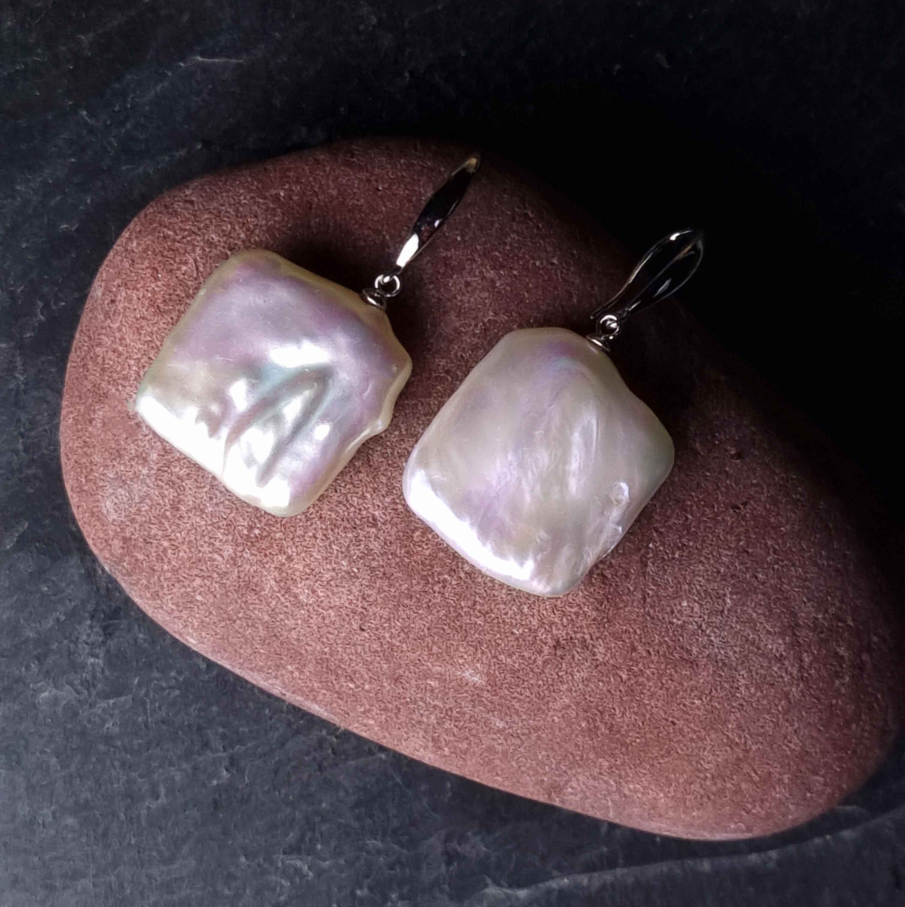 Witte zoetwater parel oorbellen met vierkanten parels en sterling zilver (925) liggend op rode steen| Dangling Pearl Square