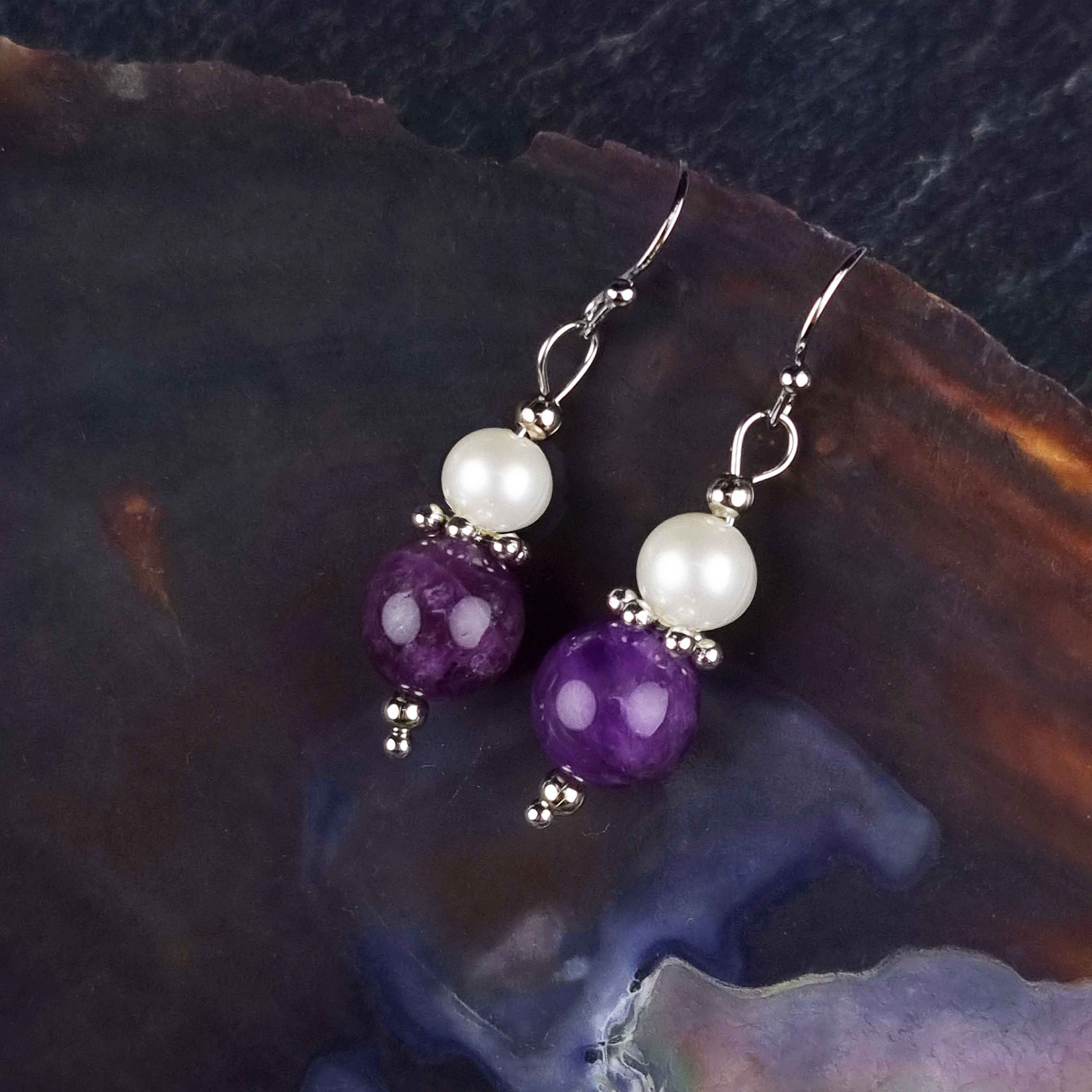 Witte zoetwater parel oorbellen met amethist en sterling zilver (925) hangend aan schelp | Amilia Amethyst
