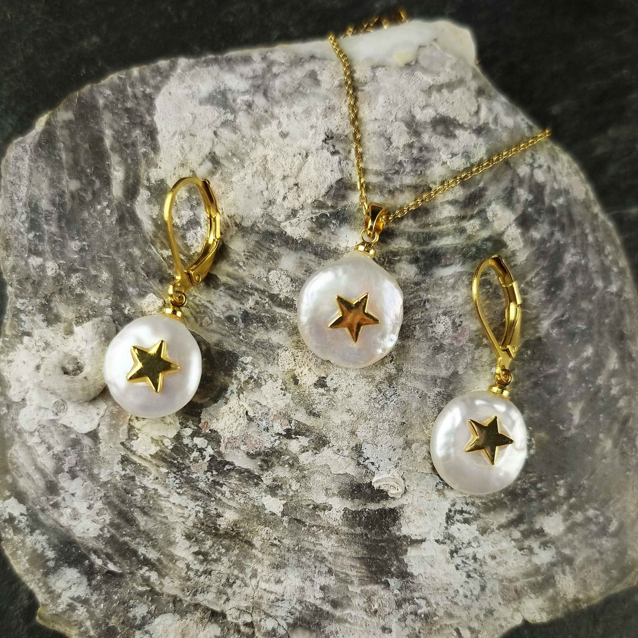 Witte zoetwater parel set bestaande uit een parelketting en parel oorbellen met goud edelstaal en parel hanger met gouden ster liggend op een schelp | set Coin Pearl Golden Star