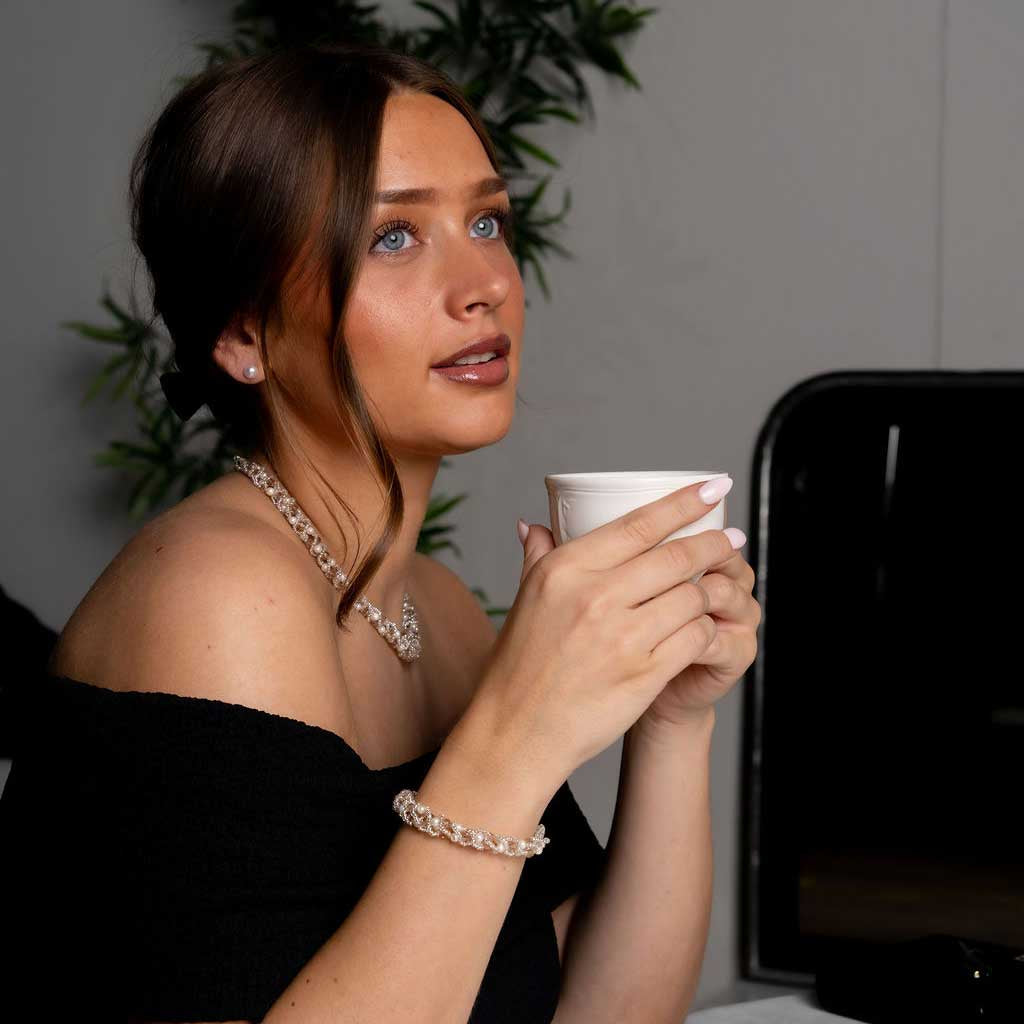 Witte zoetwater parel set bestaande uit een parelketting en parel armband met beige glaskristallen met model drinkt thee | set Pearl Crystal Clear