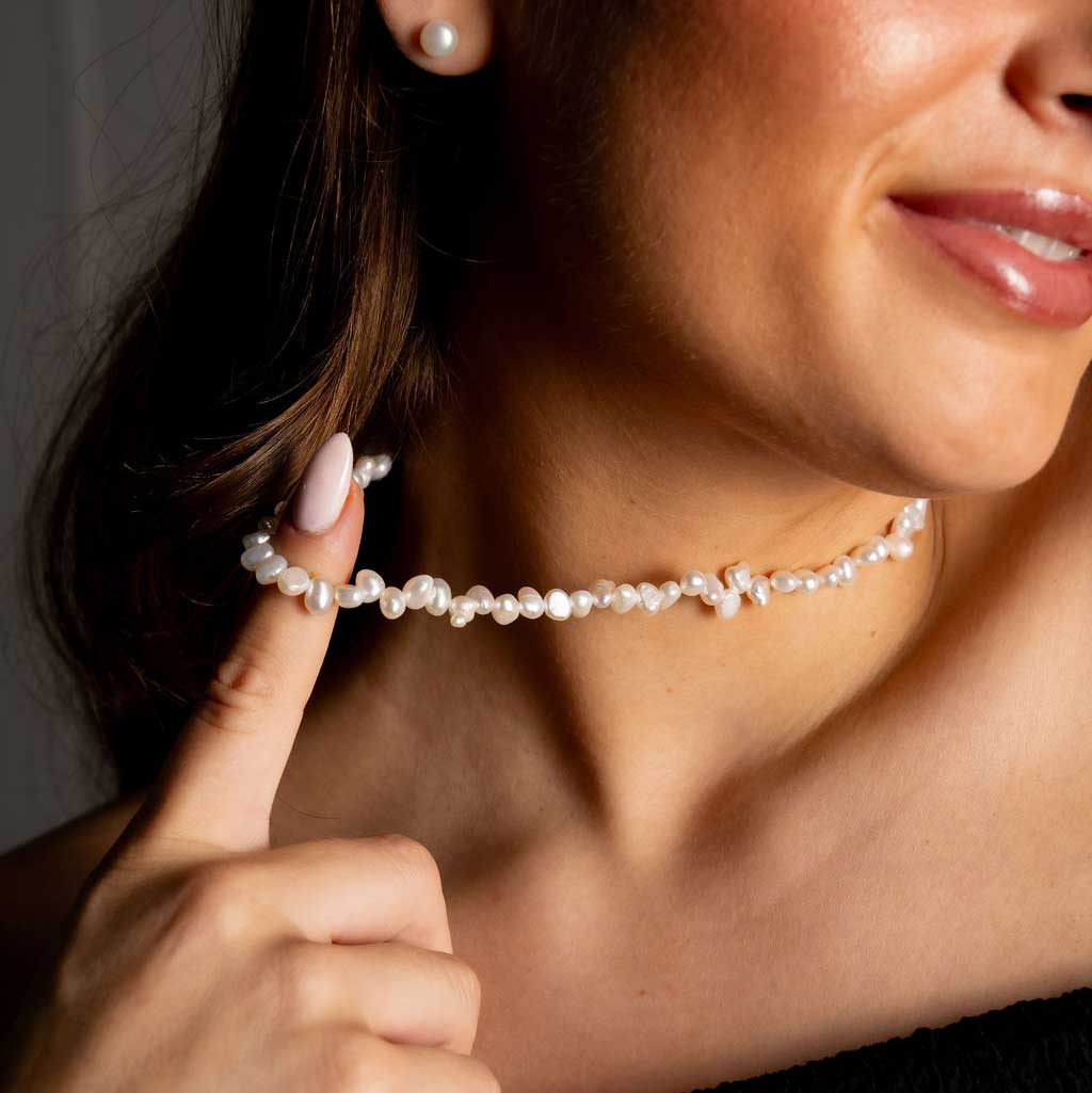 Zoetwater parelketting met kleine witte parels en goud edelstaal op model detail | Adalyn