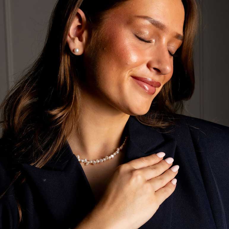 Zoetwater parelketting met kleine witte parels en goud edelstaal op model met zwart jasje | Adalyn