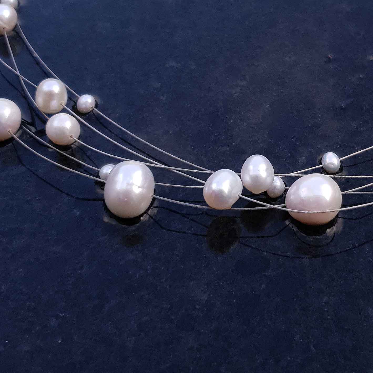 Zoetwater parelketting met witte parels en sterling zilver in 5 rijen liggend op leisteen detail | Avetta