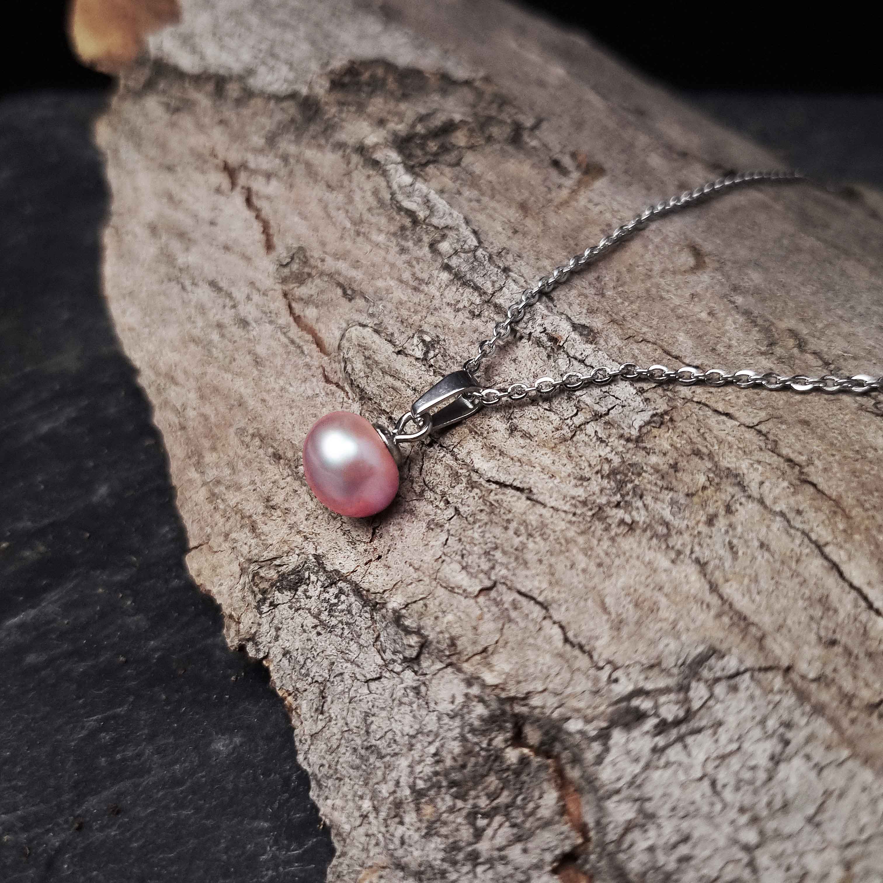 Zoetwater parelketting met roze parels en zilver edelstaal liggend op schors | set Brit P