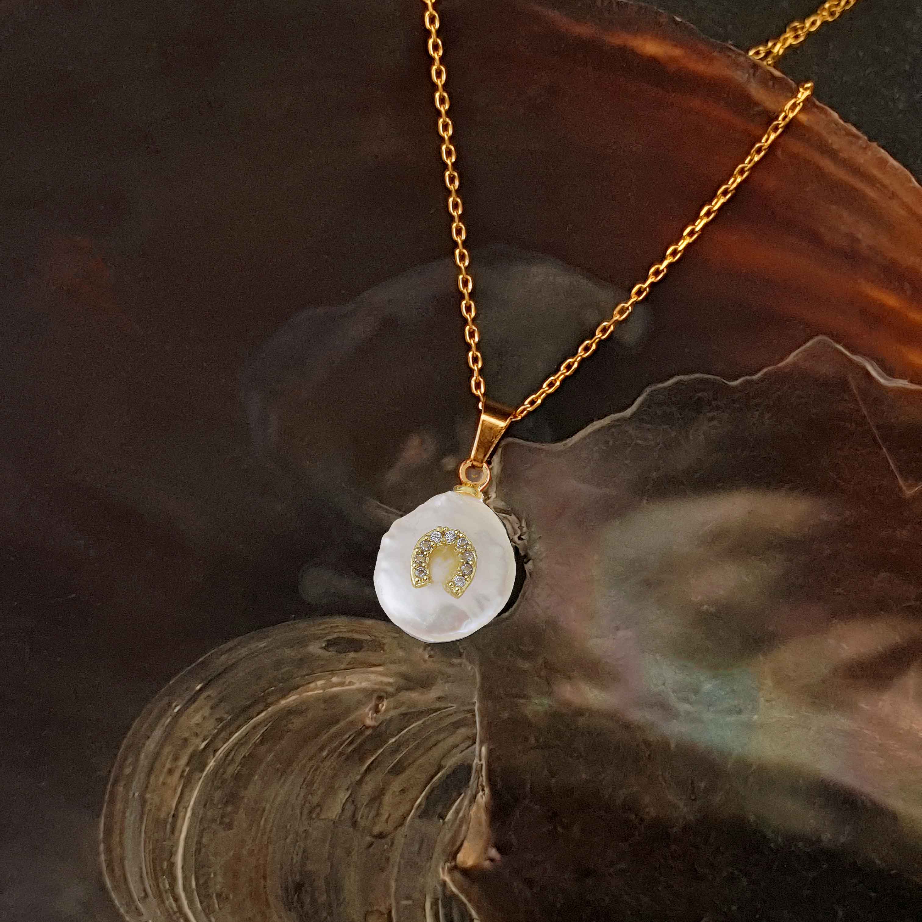 Witte zoetwater parelketting met witte parel hanger met stras steentjes in hoefijzer motief en goud edelstaal liggend in schelp | Coin Pearl Good Luck