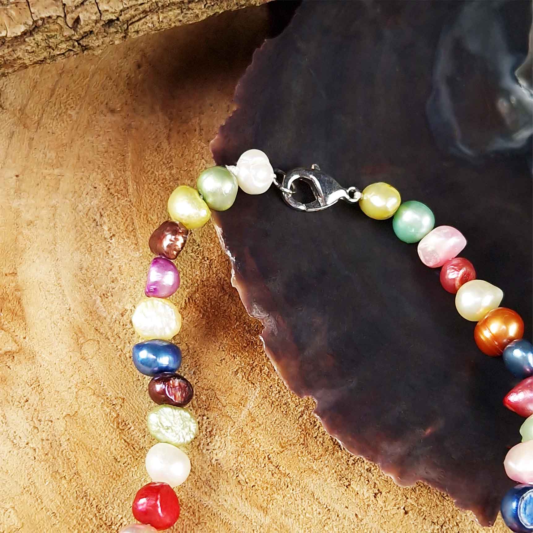 Detail van zoetwater parelketting met vrolijk gekleurde parels en sterling zilver (925) liggend in schelp | Decorative Pink