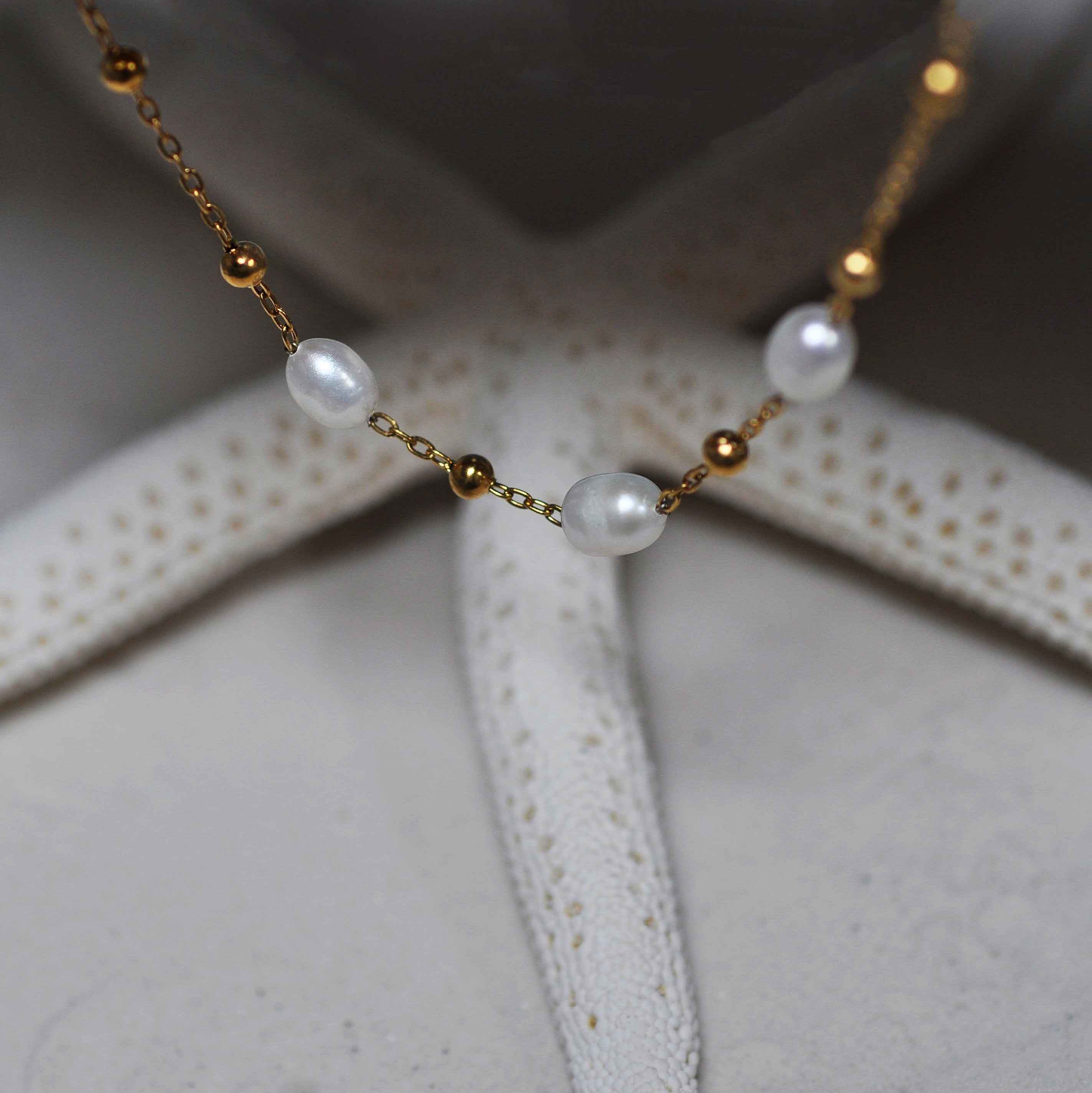 Witte zoetwater parelketting met goud edelstaal hangend voor zeester | Parelketting Eline Goud