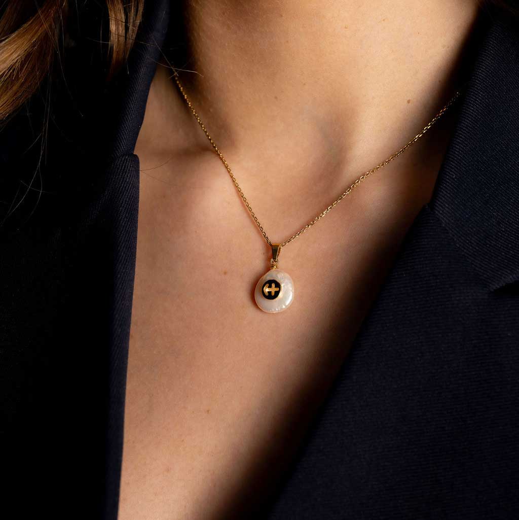 Detail van zoetwater parelketting met witte parel hanger met gouden symbool van sterrenbeeld boogschutter en goud edelstaal op model detail | Gouden Sterrenbeeld Boogschutter