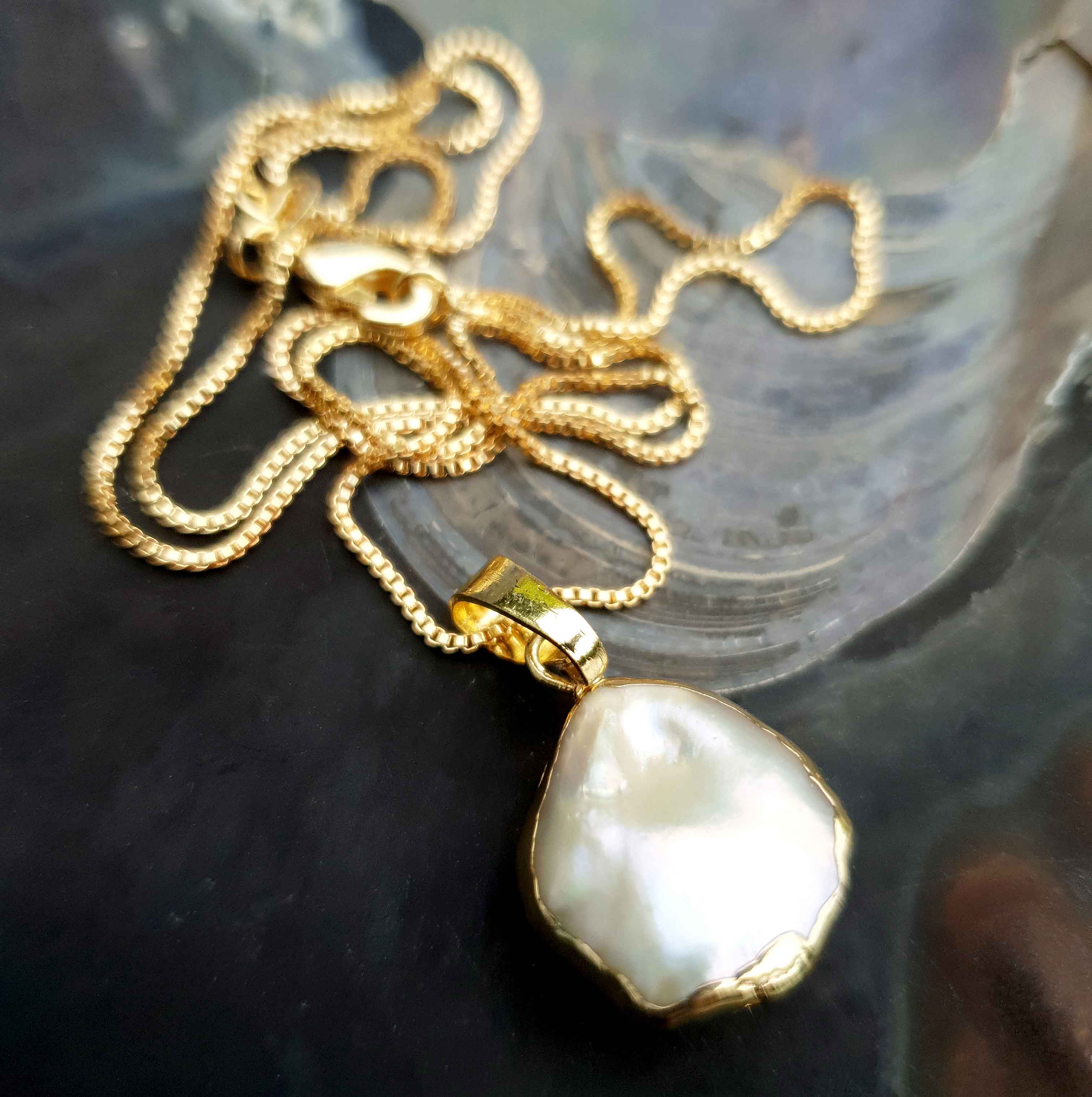 Zoetwater parelketting met witte parel hanger liggend in schelp | One Gold Coin Pearl Chain