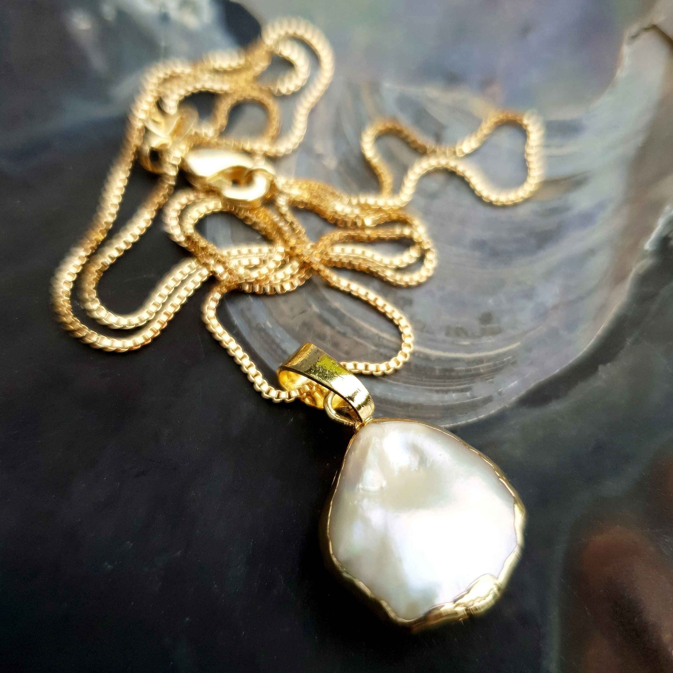Zoetwater parelketting met witte parel hanger liggend in schelp | One Gold Coin Pearl Chain