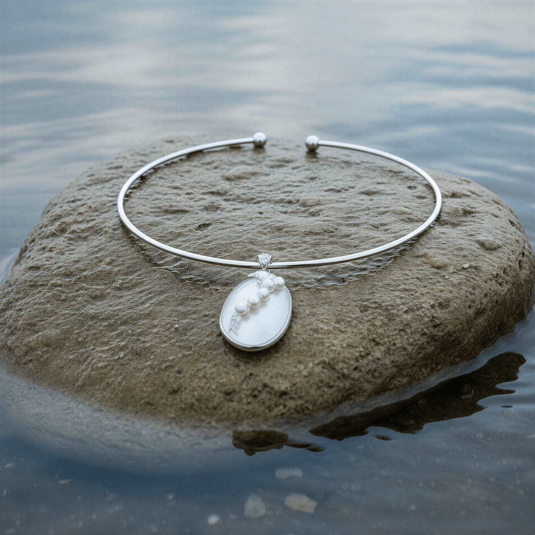 Korte zoetwater parelketting met witte parels en een witte schelp liggend op steen in water | Shell Pearl Grape