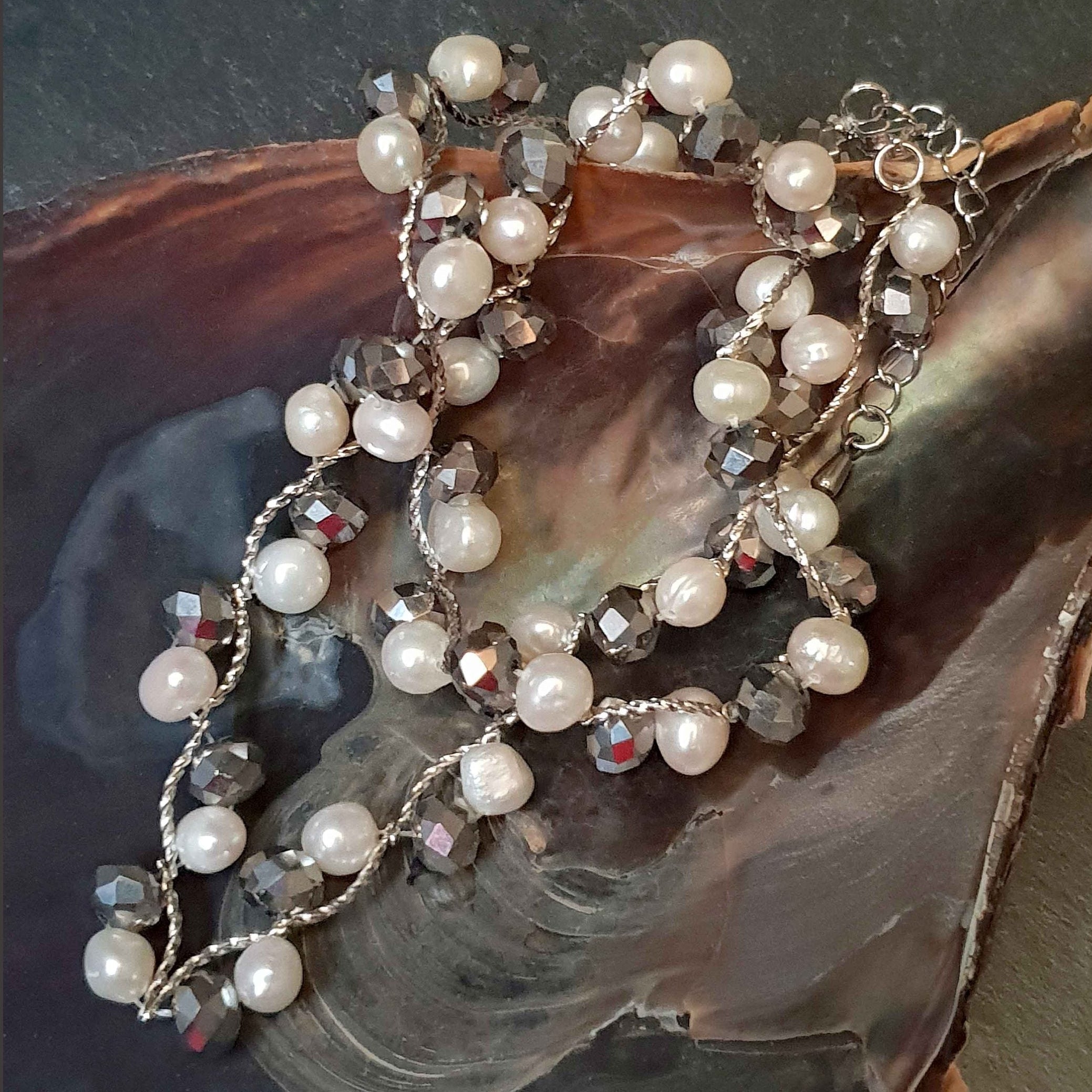 Witte zoetwater parelketting met zilver facet geslepen glas kristallen liggend in schelp | Silana