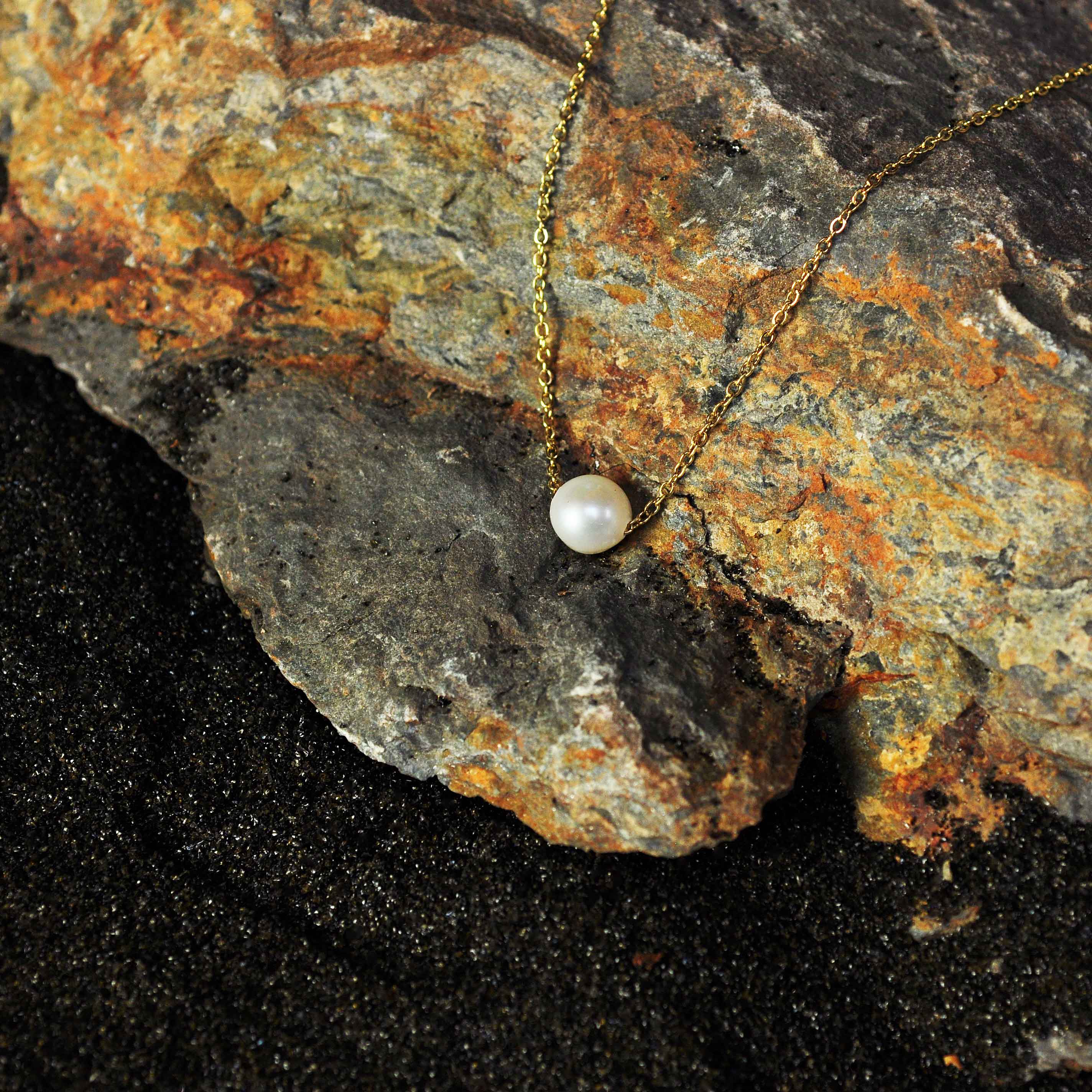 Zoetwater parelketting met witte parel aan goud edelstalen ketting liggend op steen | Single One Pearl Gold