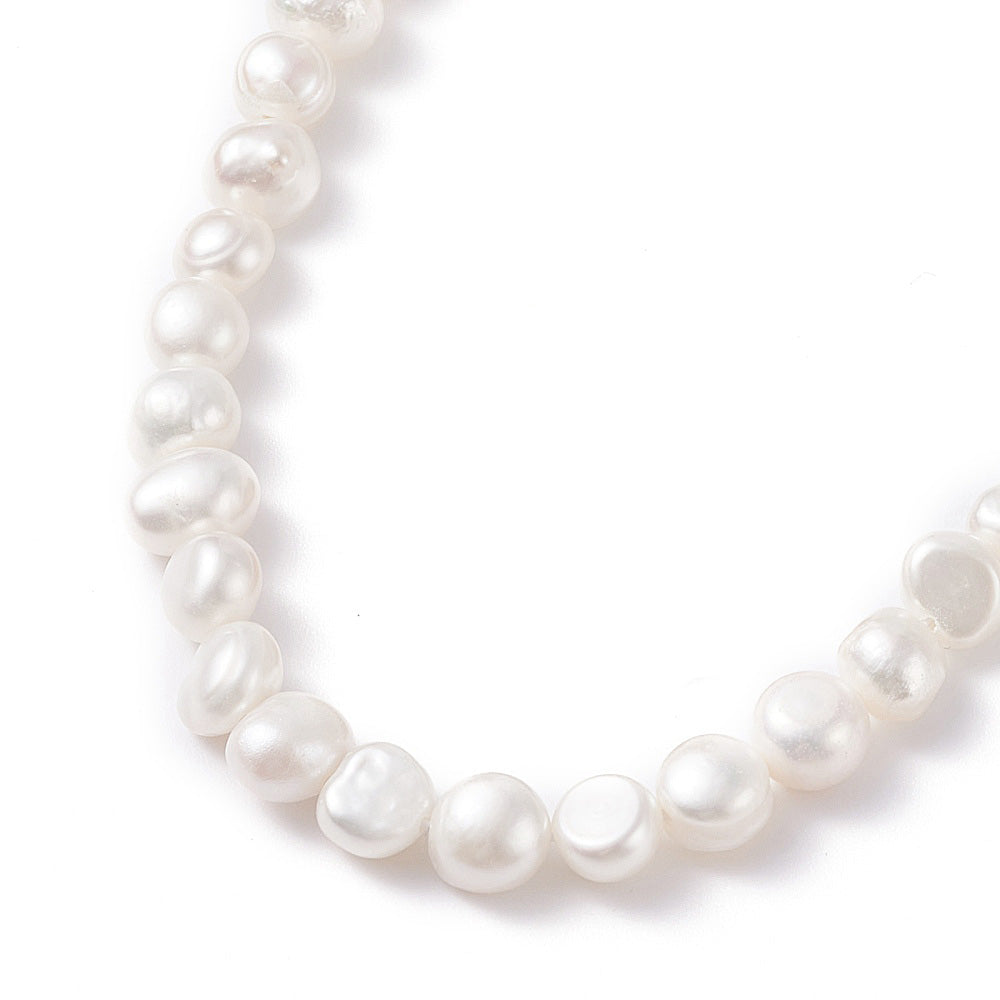 Detail van witte zoetwater parelketting met goud edelstaal en verlengketting