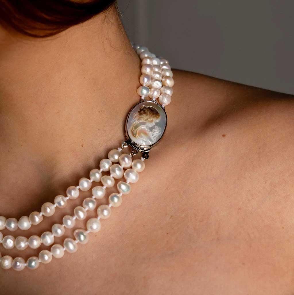 Handgeknoopte zoetwater parelketting met witte parels in 3 rijen en parelmoeren slotje op model detail | Victoria