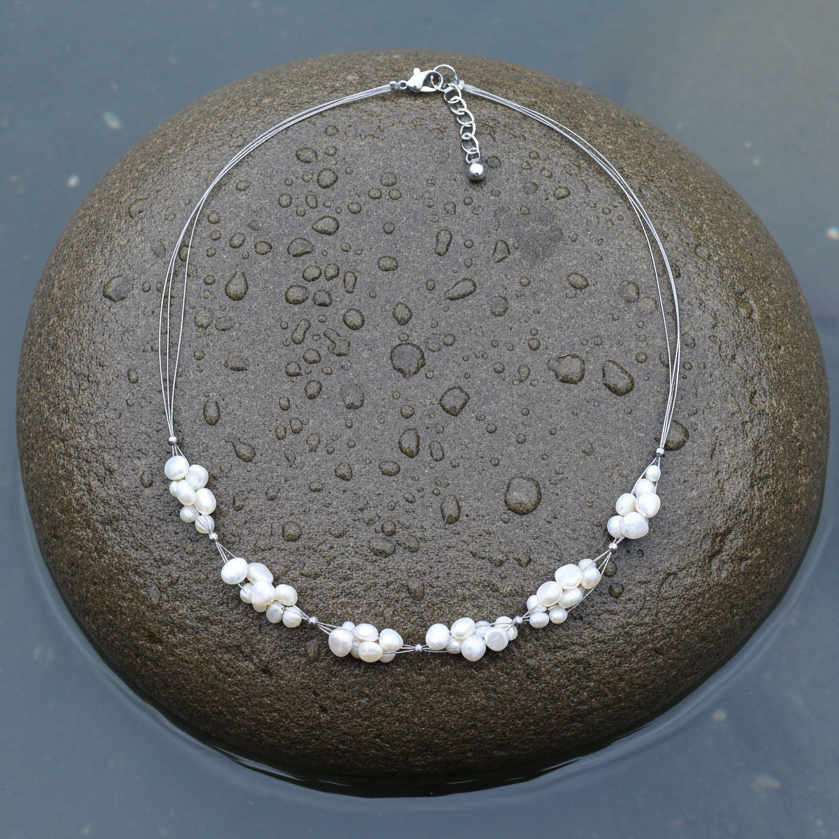 Zoetwater parelketting met witte parels en sterling zilver (925) liggend op steen | Winny