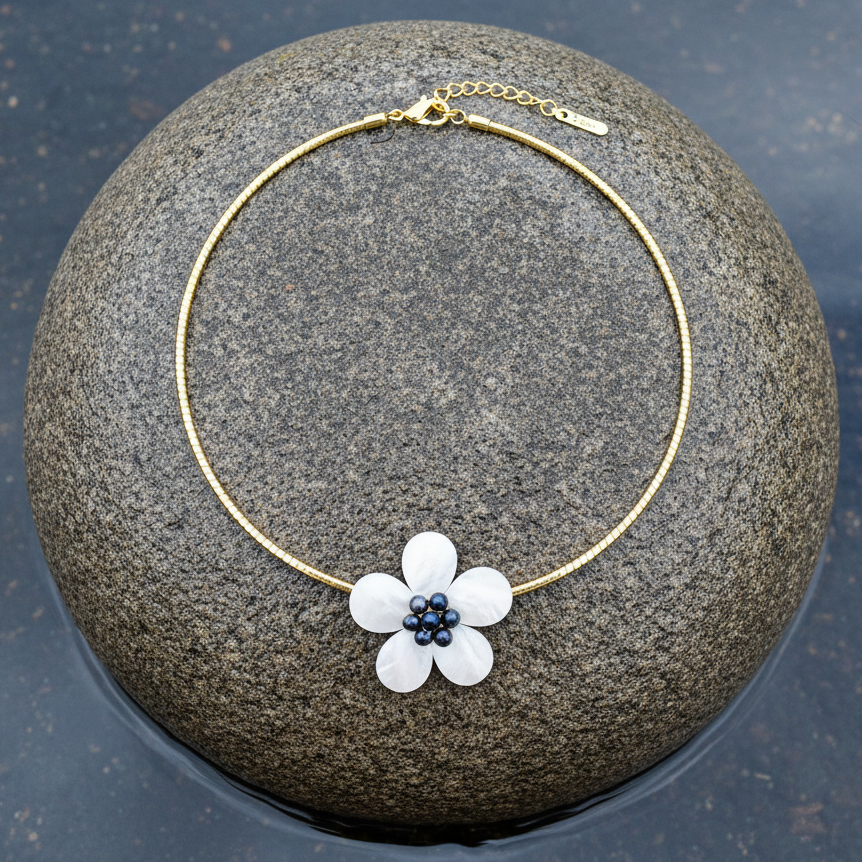 Zoetwater parelketting met parelmoeren bloem aan goud edelstalen ketting liggend op steen | set Fleury B Gold