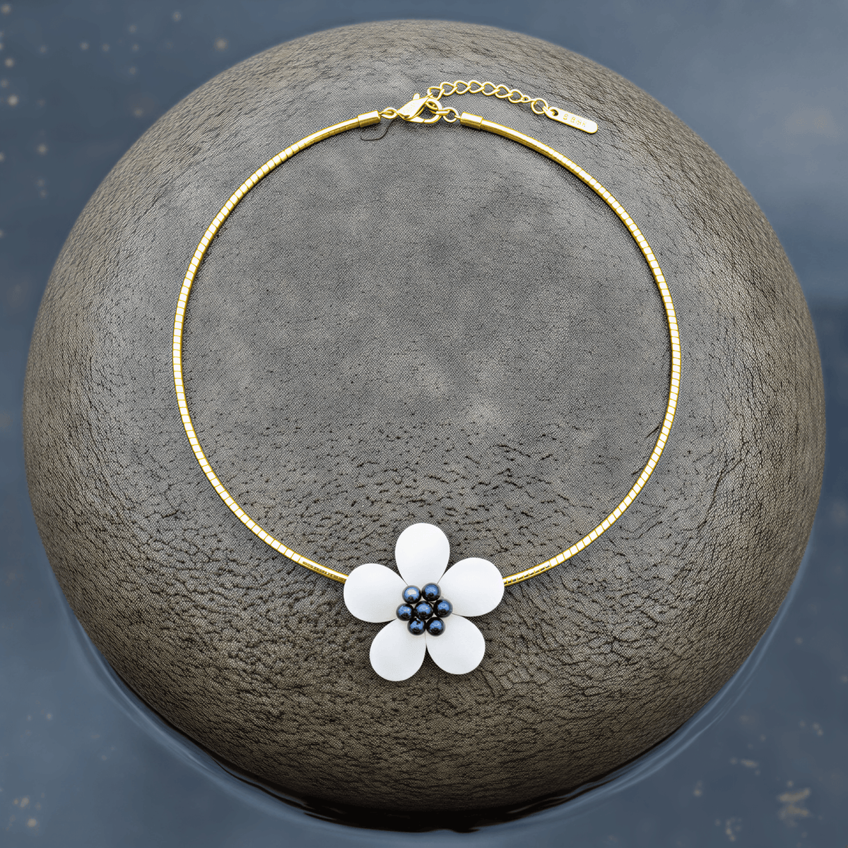 Zoetwater parelketting met parelmoeren bloem aan goud edelstalen ketting liggend op steen | set Fleury B Gold