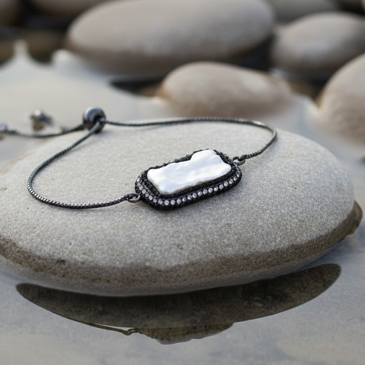 Wit zoetwater parel armband met stras steentjes en schuifsluiting liggend op steen in water | Black Bright Biwa Pearl