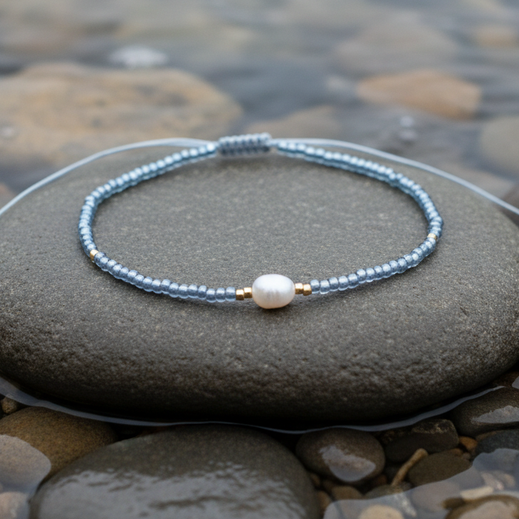 Wit zoetwater parel armband met licht blauwe kraaltjes liggend op steen in water | Mini Pearl One Shiny Light Blue