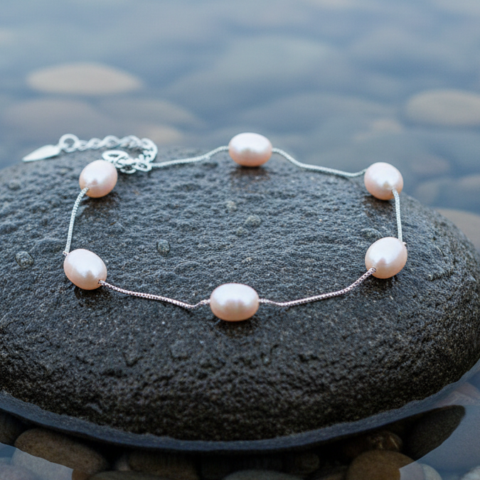 Zoetwater parel armband met zalm roze parels liggend op natte steen | Pearl Chain Peach