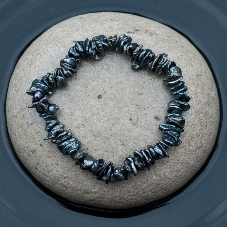 Zoetwater parel armband met blauw grijze keshi parels liggend op natte steen, elastisch | Peshi