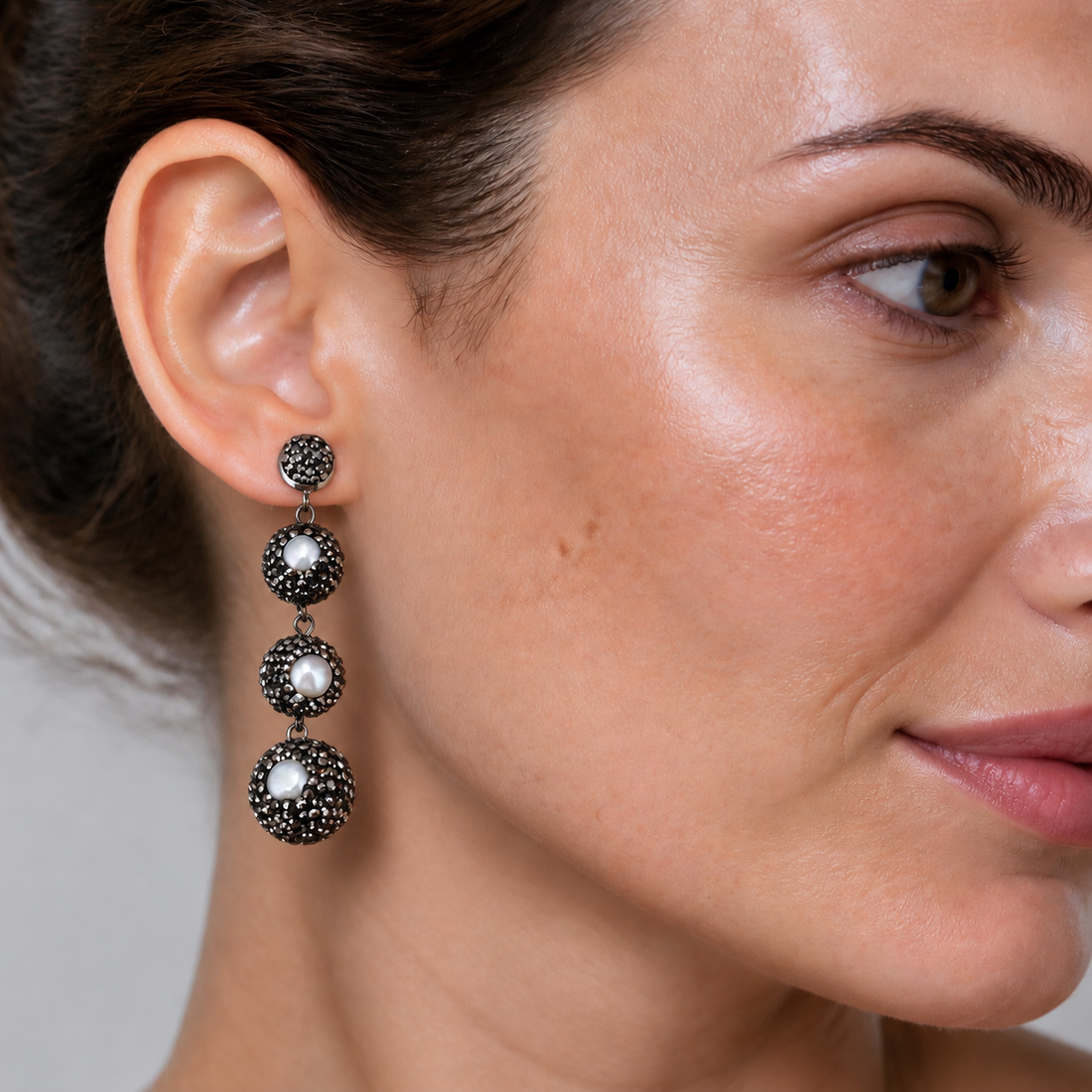 Lange zoewater parel oorbellen met witte parels en zwarte stras steentjes op model | Bright Pearl Balls