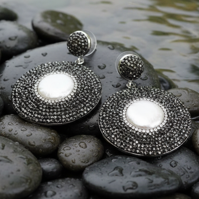 Grote witte zoetwater parel oorbellen met stras steentjes liggend op stenen in water | Bright Pearl Disc