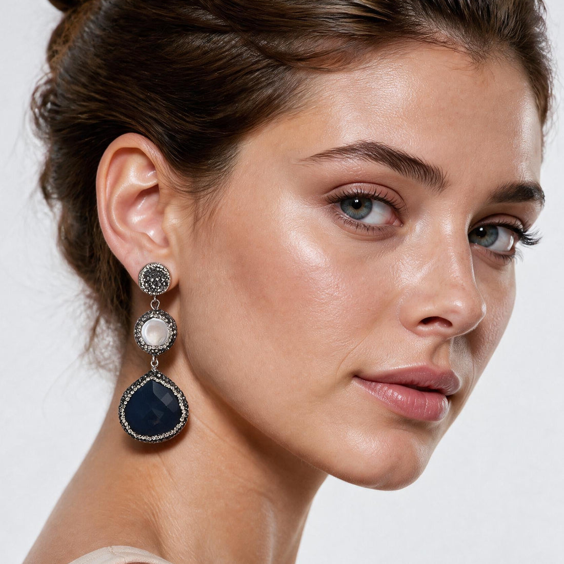 Lange witte zoetwater parel oorbellen met stras steentjes en donker blauwe kattenoog op model | Bright Long Pearl Dark Blue Cat’s Eye